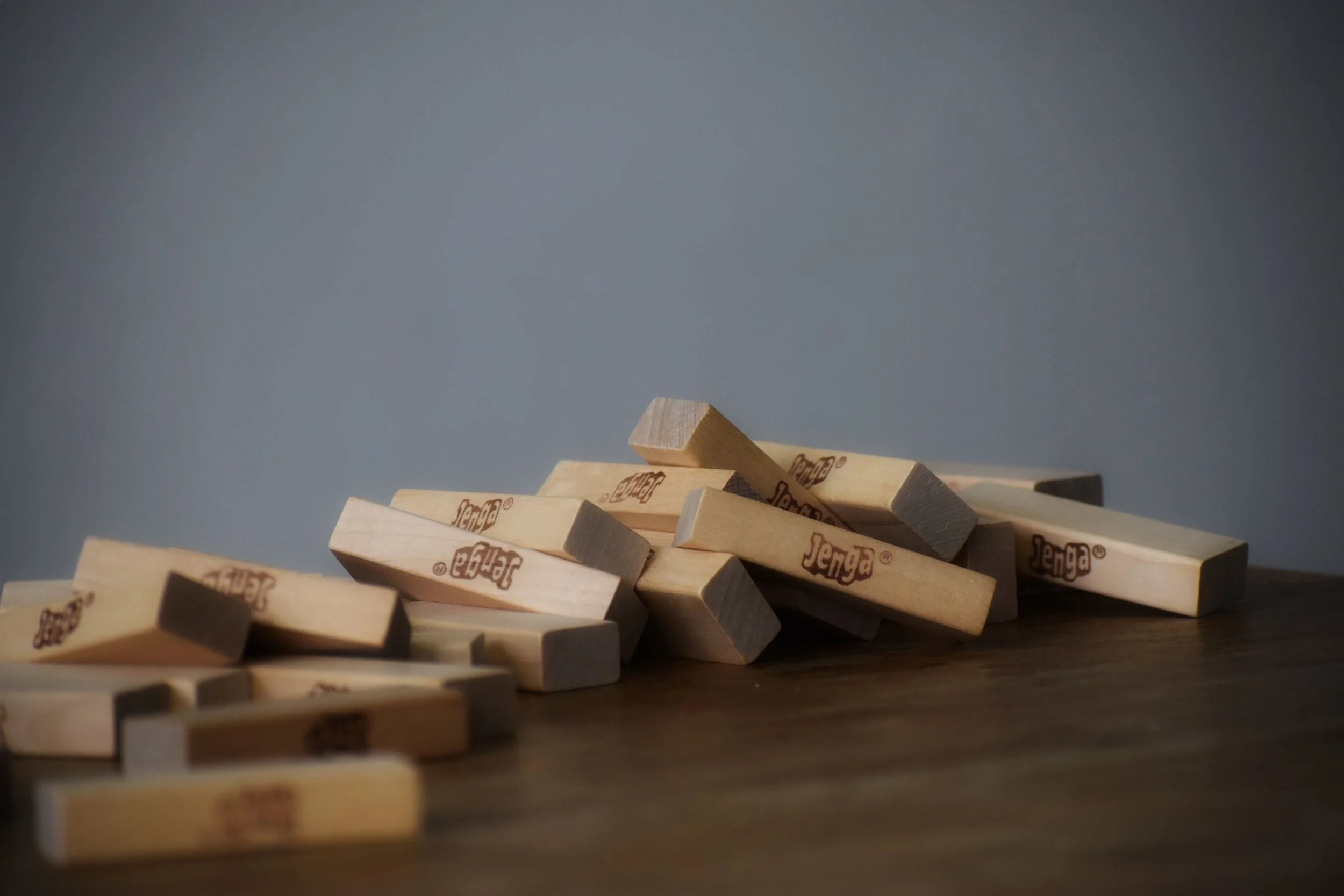 stacked jenga blocks falling over, demonstrating ADHD overwhelm and therapy in Albany, NY
