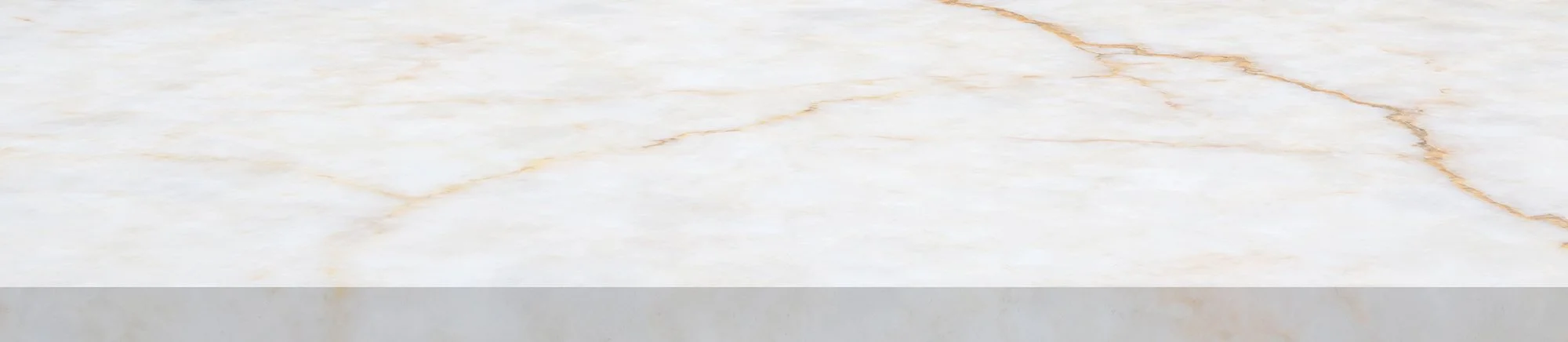 Close-up of a marble surface with white and light tan streaks.