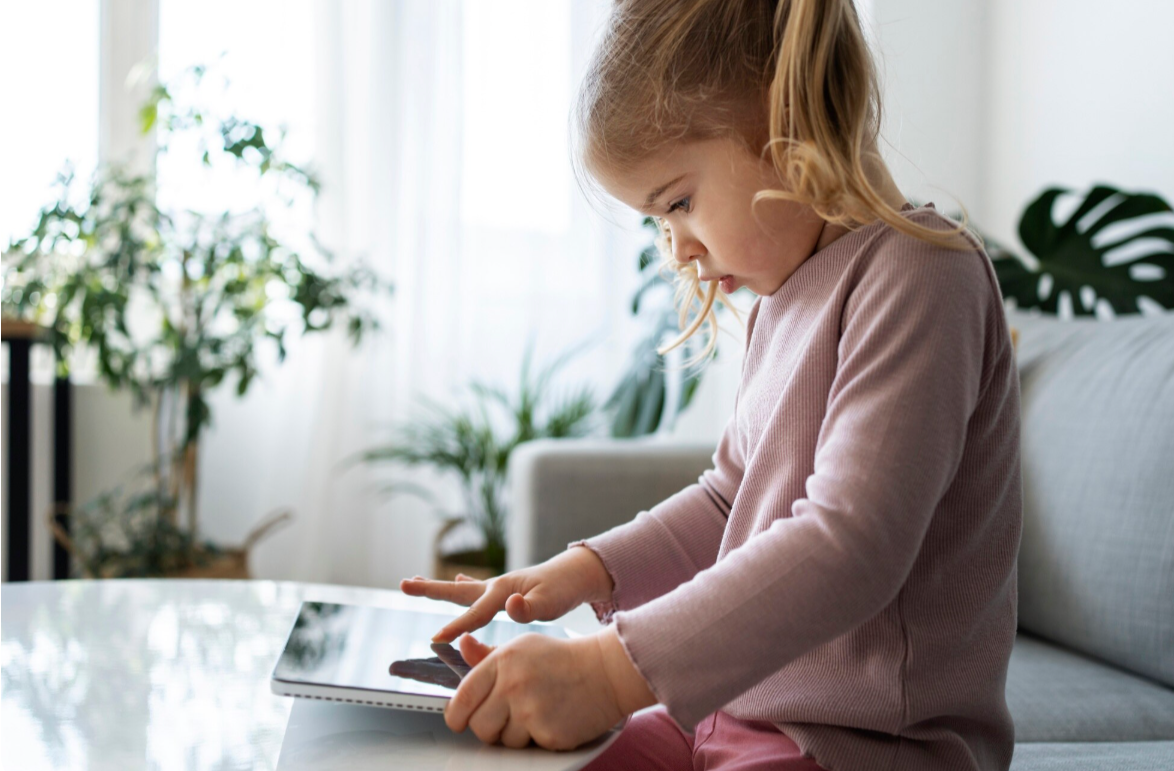 Child using communication device during community-based therapy in Bellingham, Washington.
