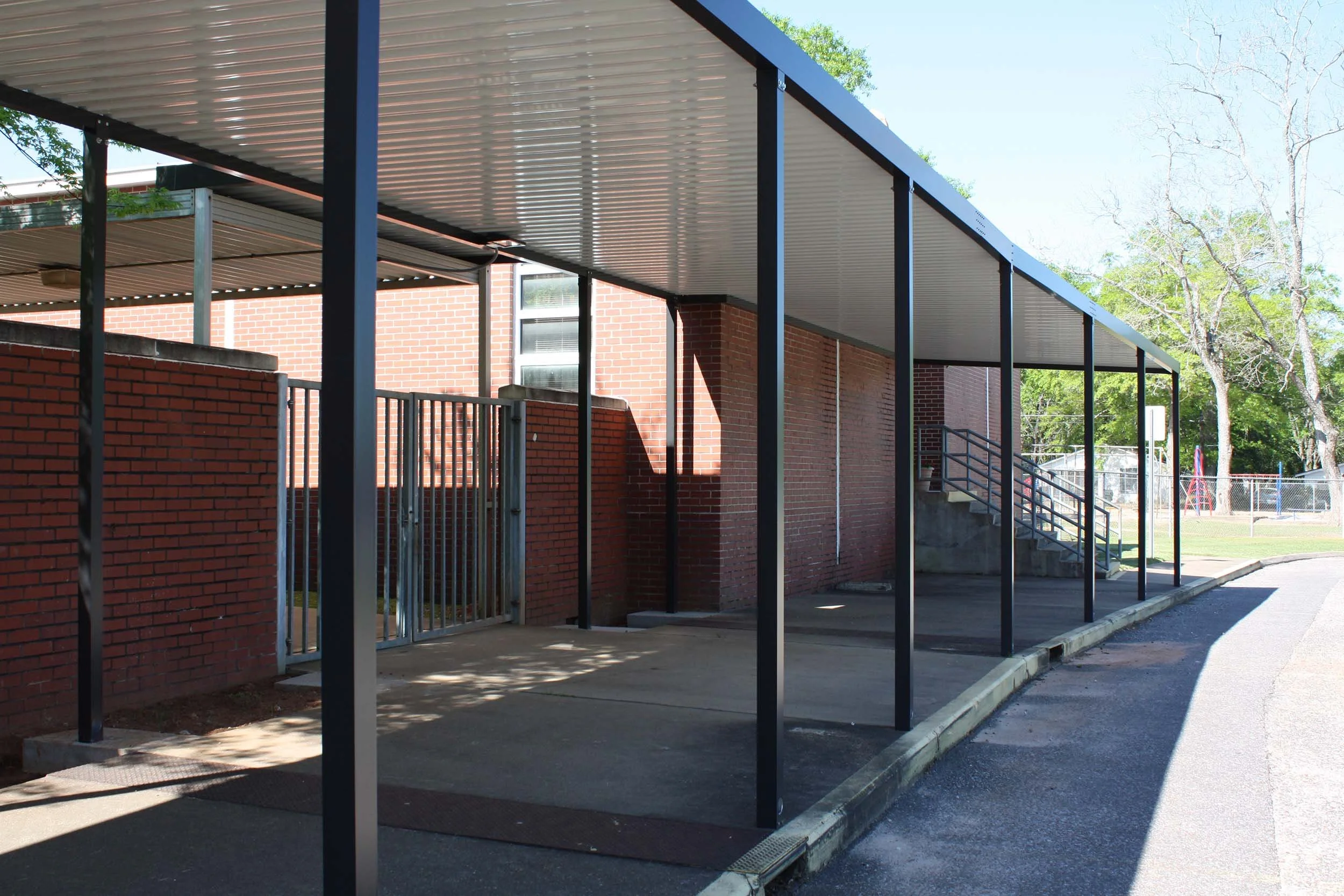 Covered walkway structure installed along a building exterior for pedestrian protection.
