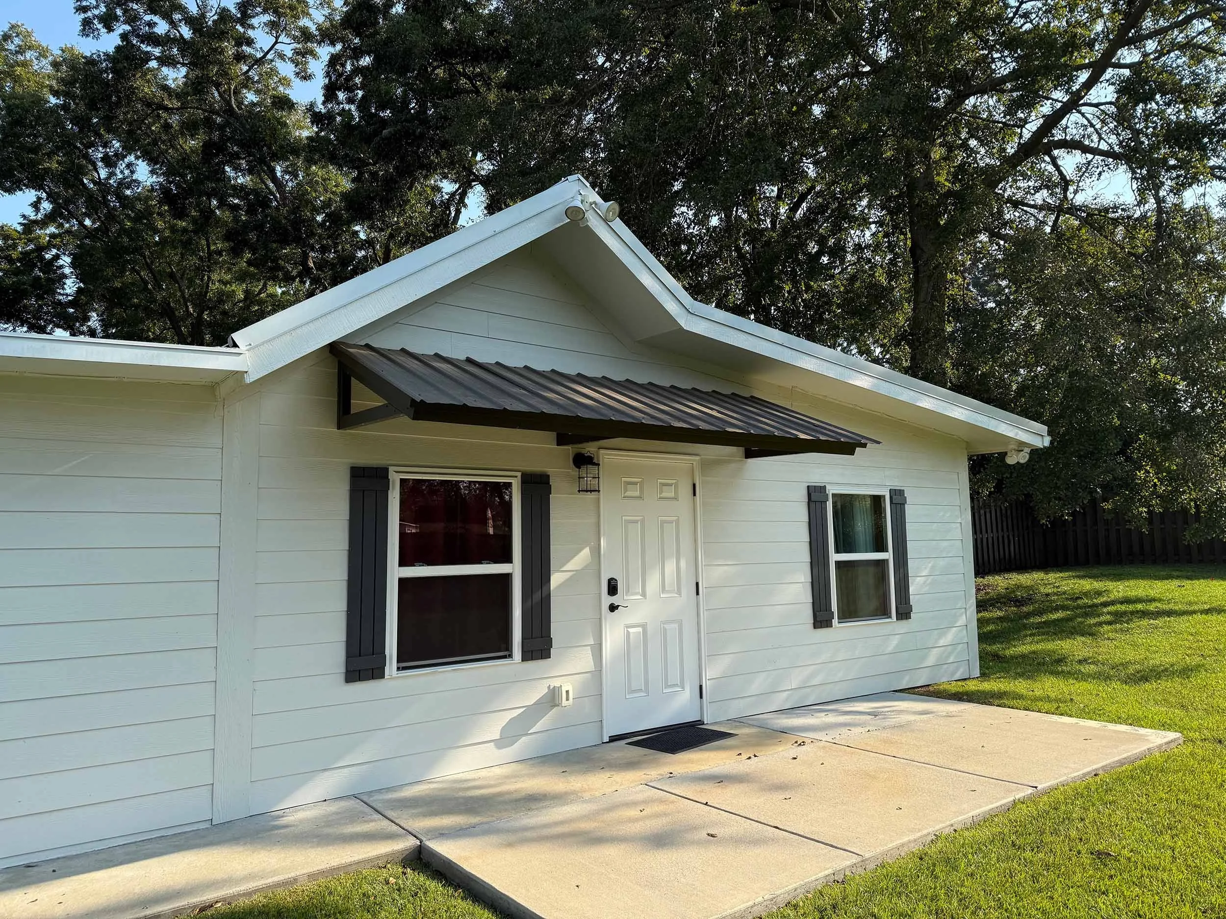 Door awning installation designed to protect a home entry from sun and rain.