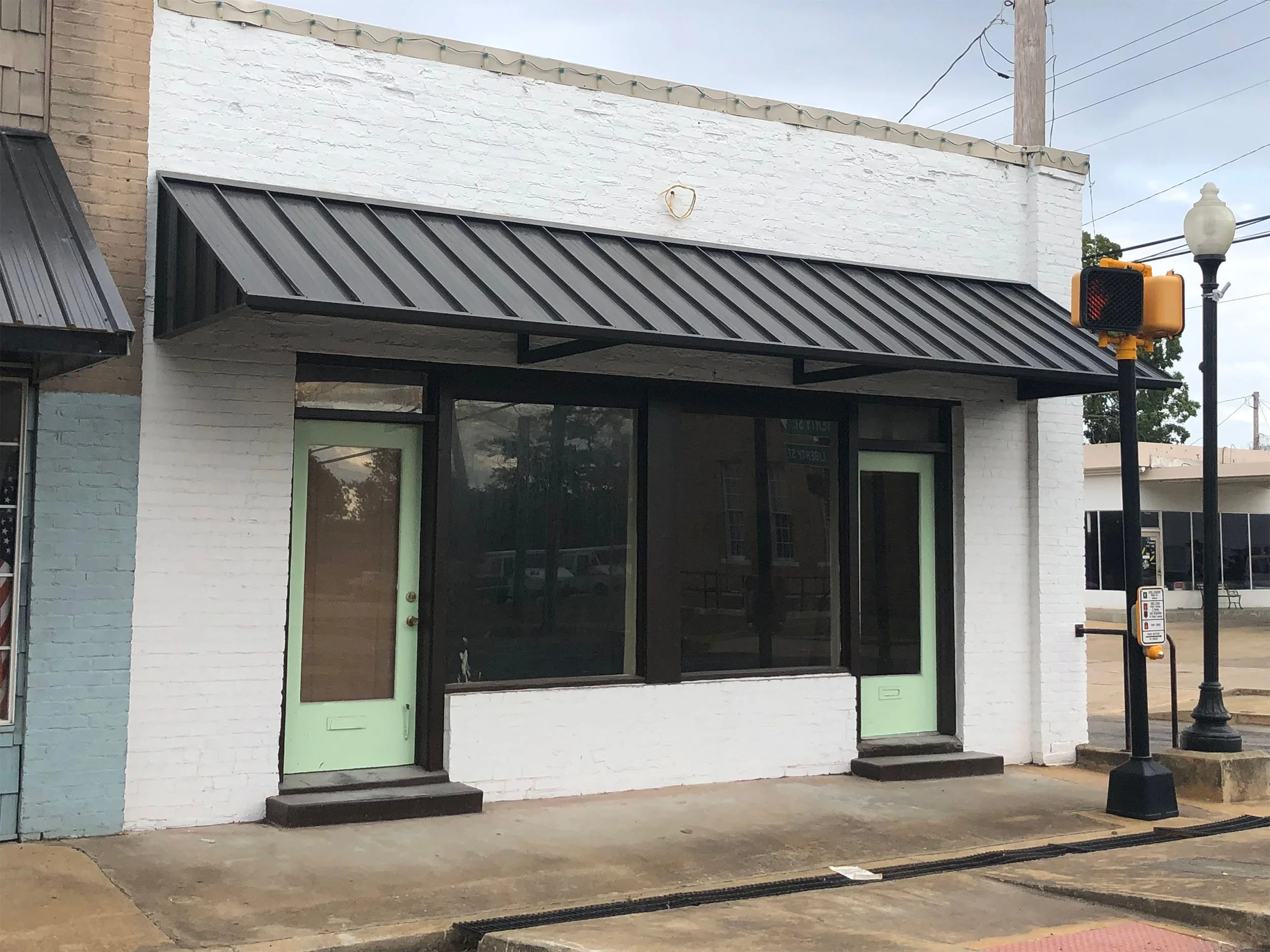 Custom business awning installed for improved visibility and customer entry protection.