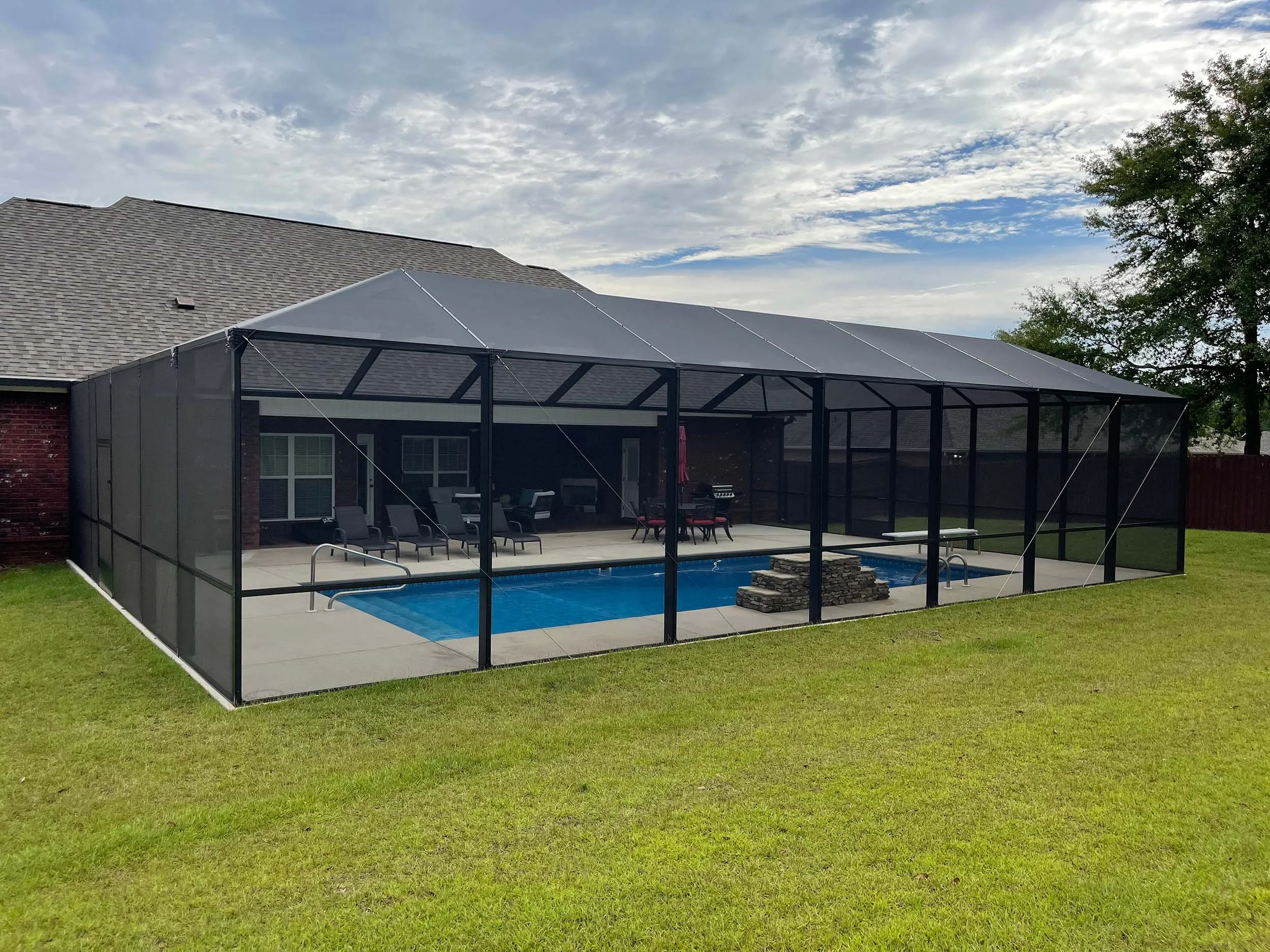 Screened pool cage designed to help keep insects and debris out of the pool area.