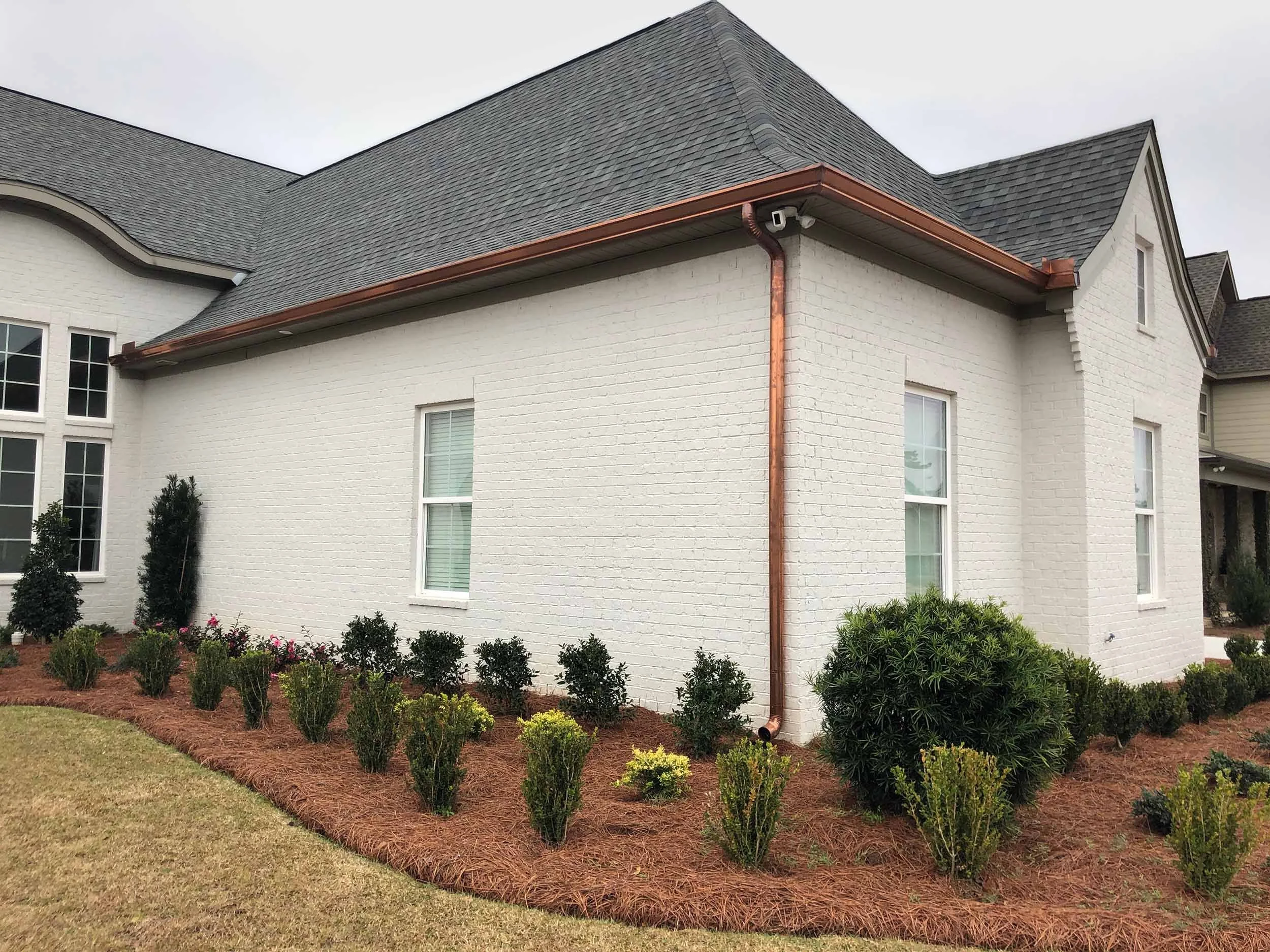 Custom seamless gutters installed on a brick home exterior.