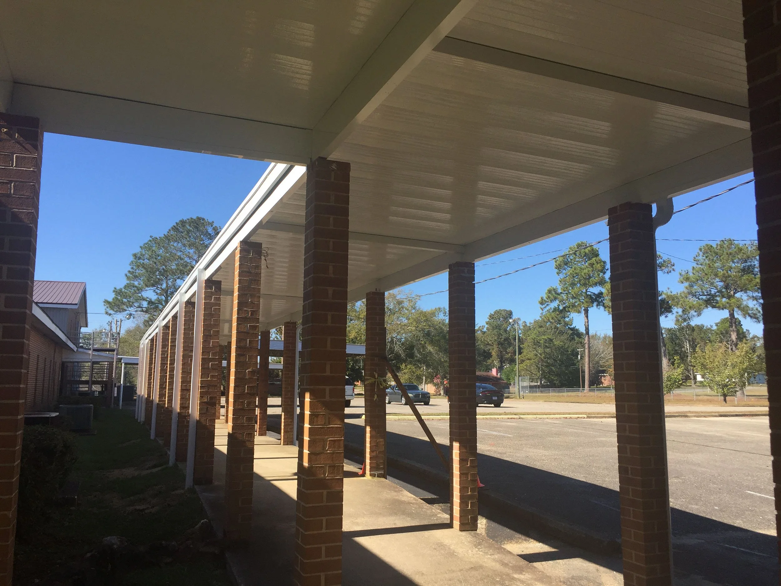 Covered pedestrian walkway serving a commercial property in the Wiregrass area.