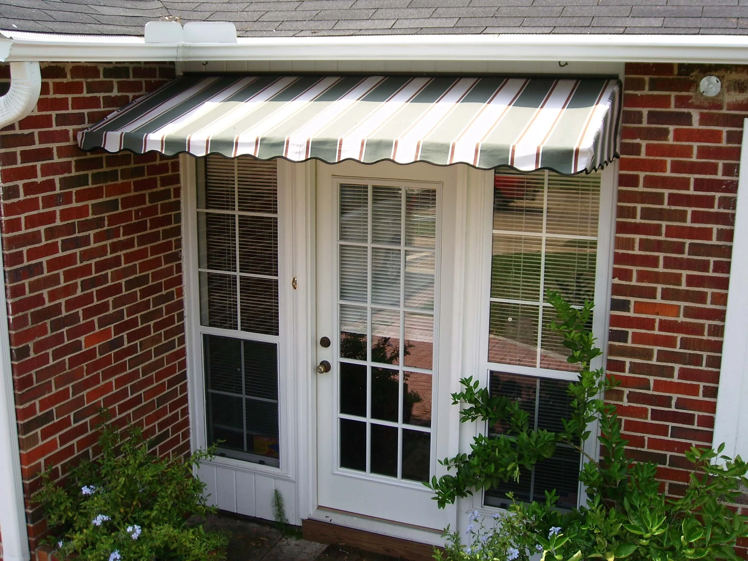 Striped awning over French doors designed for shade, comfort, and curb appeal.