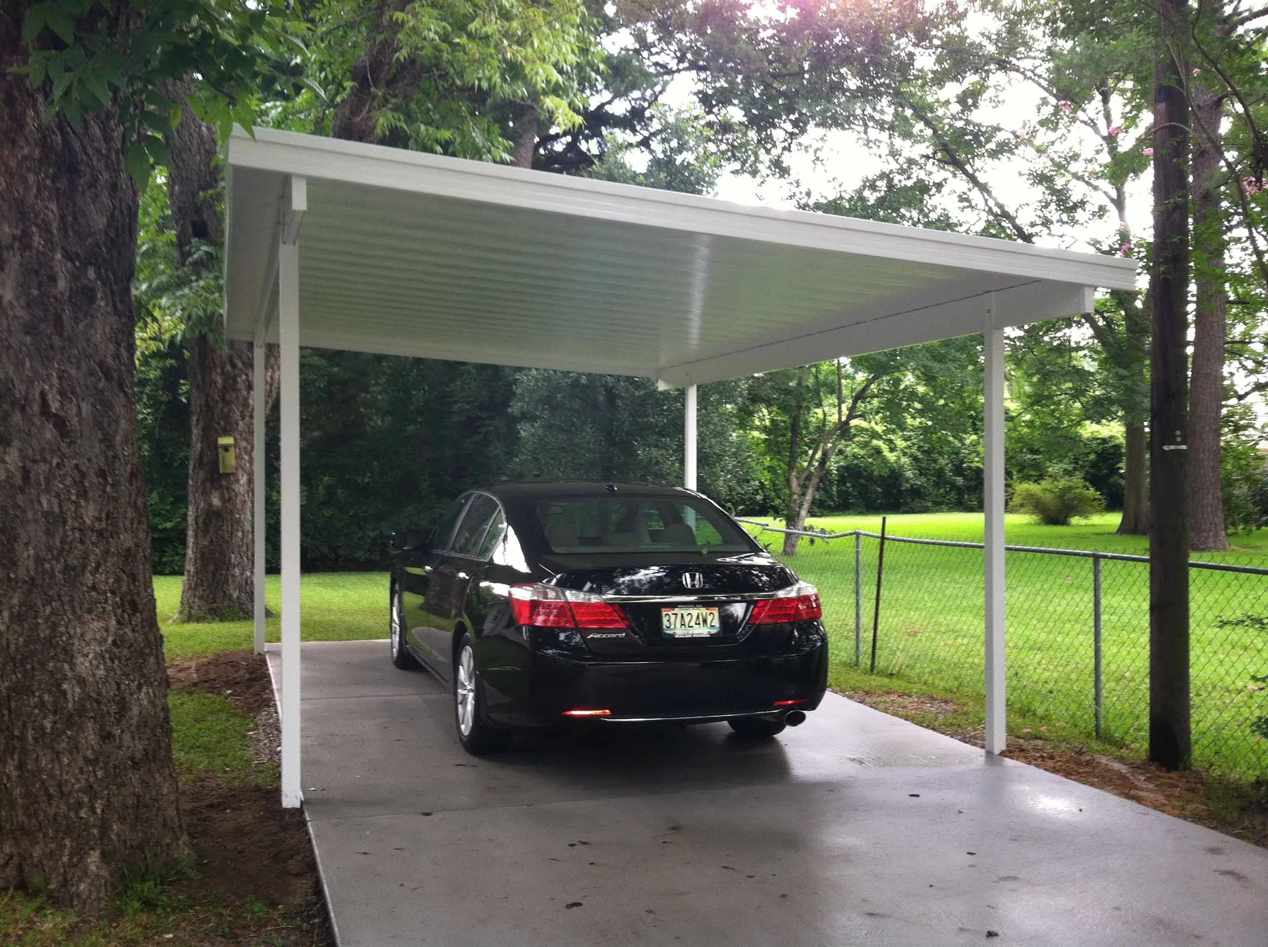 Carport installation creating a protected parking area beside the home.