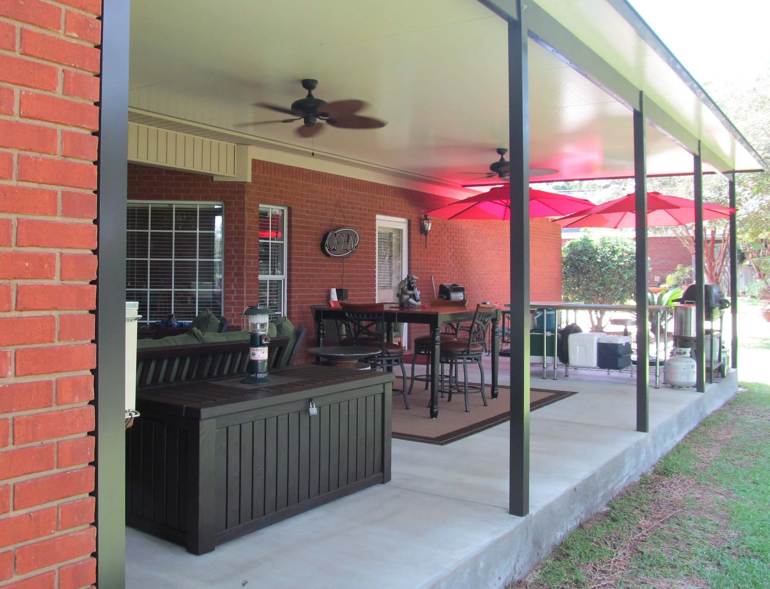 Custom patio cover built to protect an outdoor seating area from sun and rain.