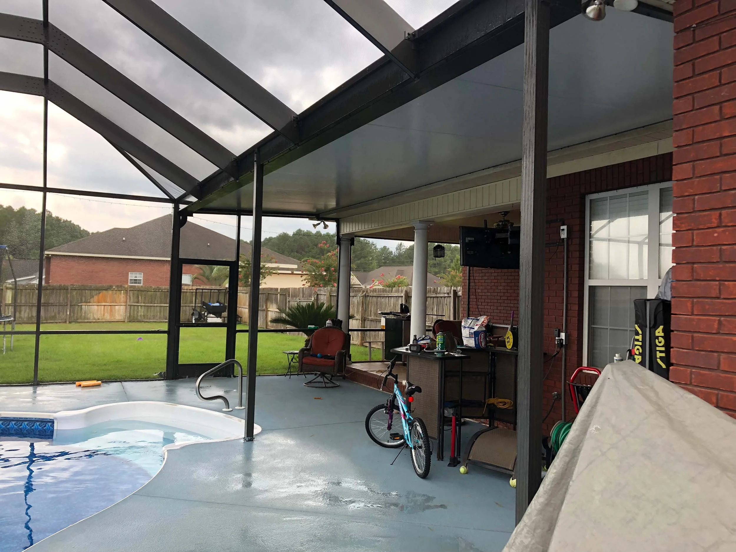 Pool enclosure designed to make a backyard pool area more usable and protected.