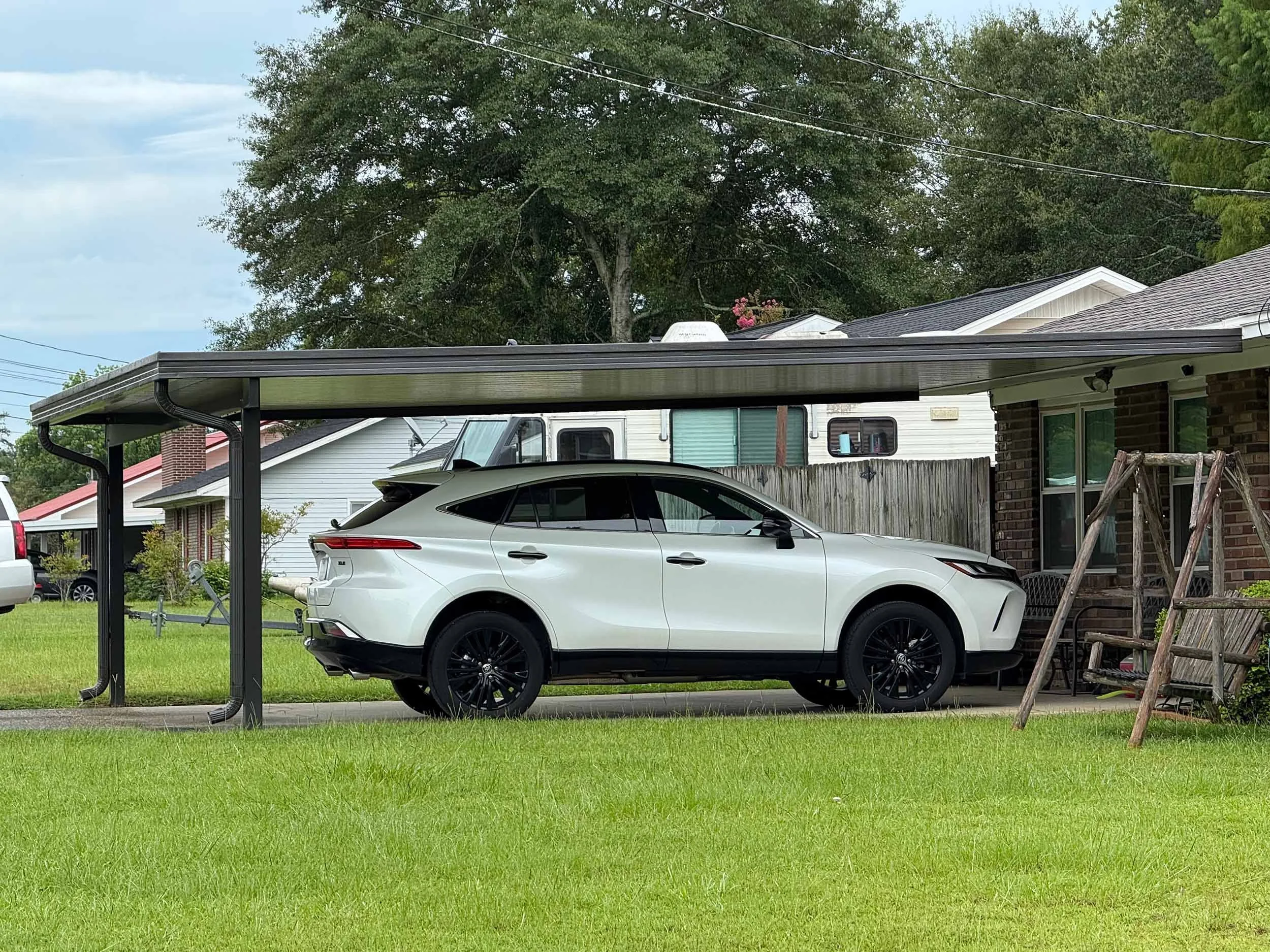 Residential carport installation for improved shade and weather coverage.