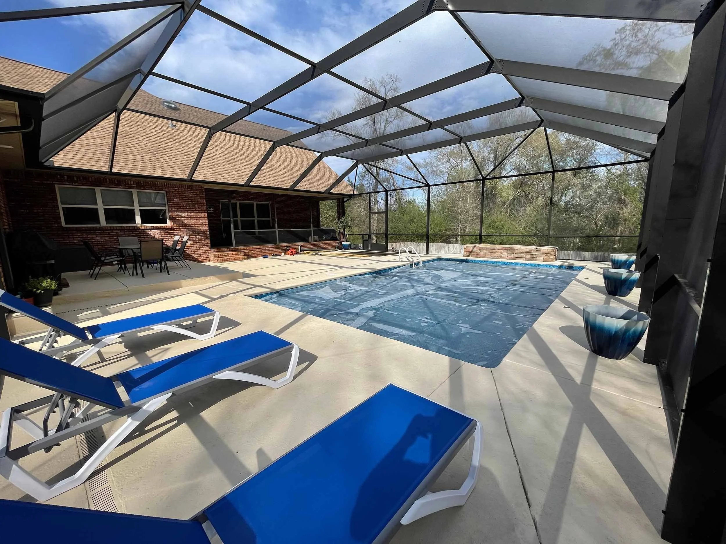 Screened pool cage installation for improved comfort around an outdoor pool.