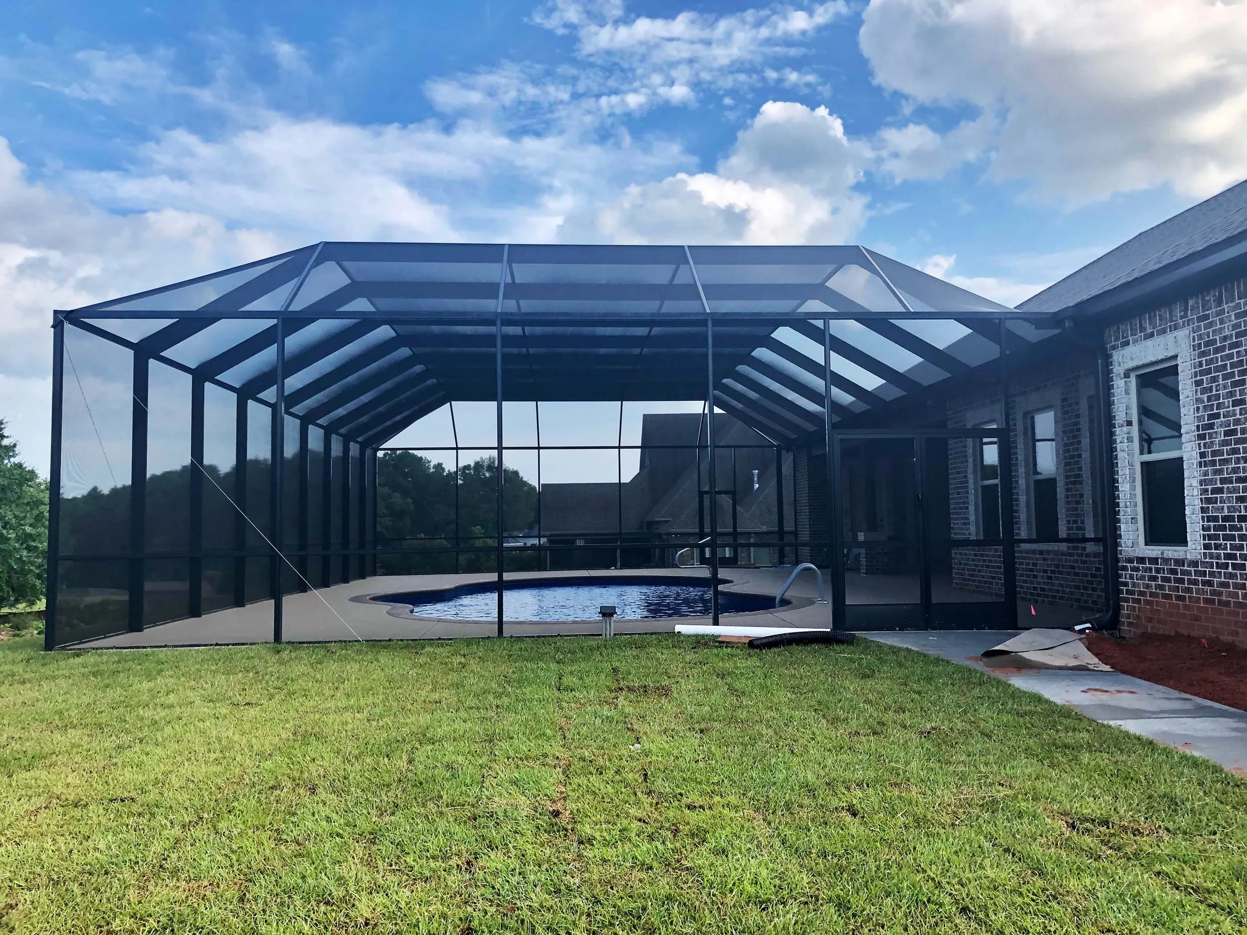 Pool cage addition designed to protect the pool area while maintaining outdoor views.