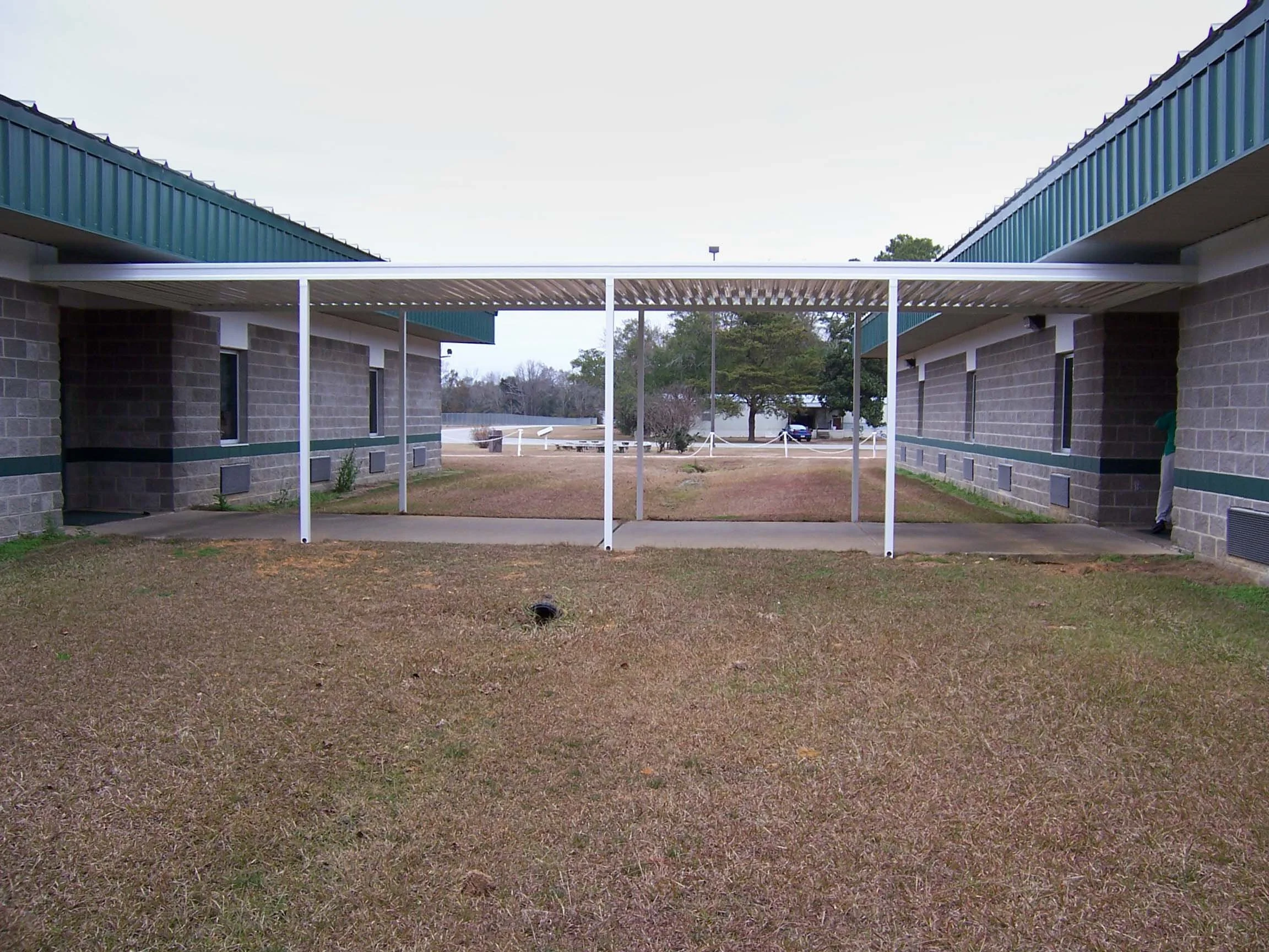 Covered walkway installation connecting building entrances and outdoor paths.