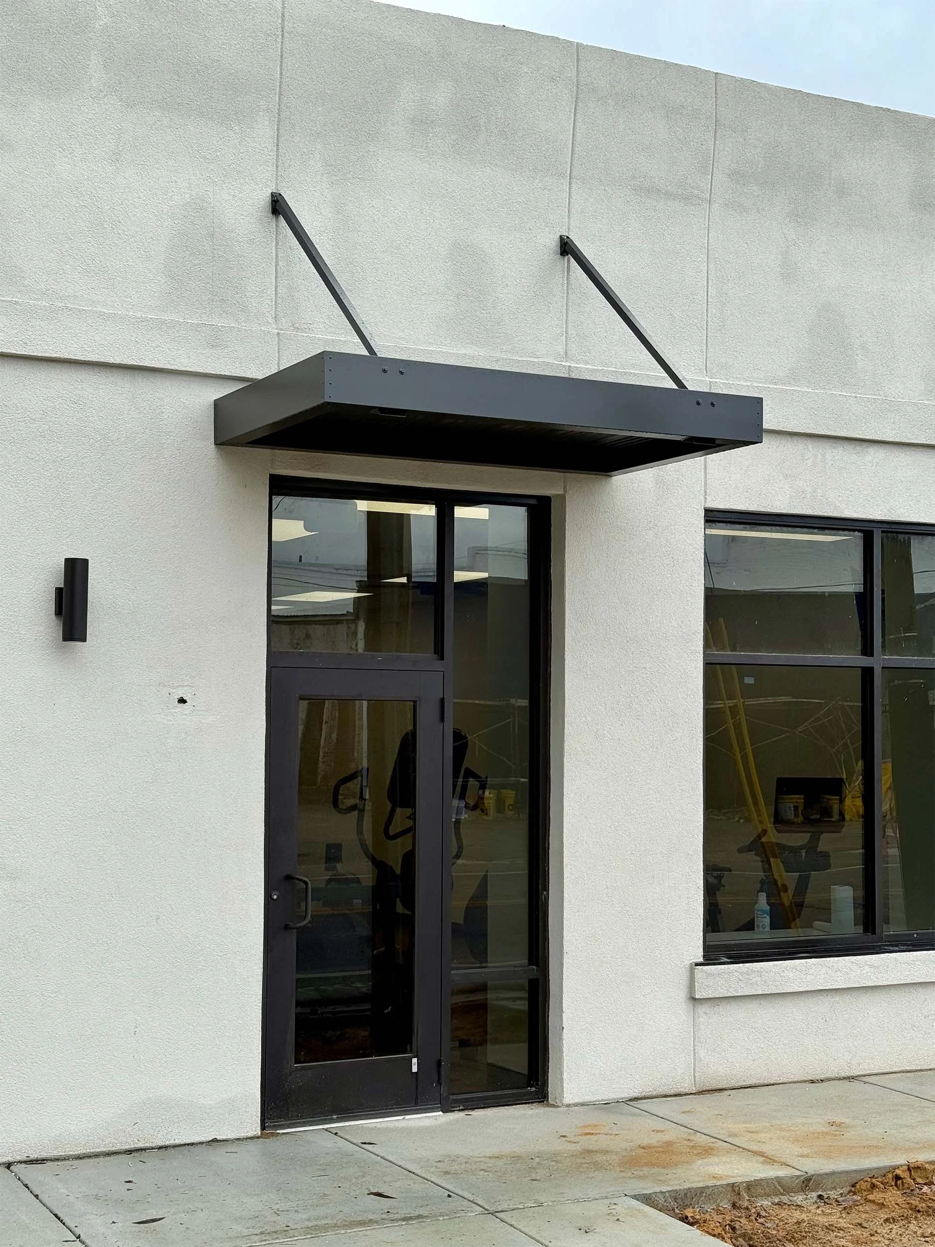 Custom awning installation for shade and protection at a commercial building.