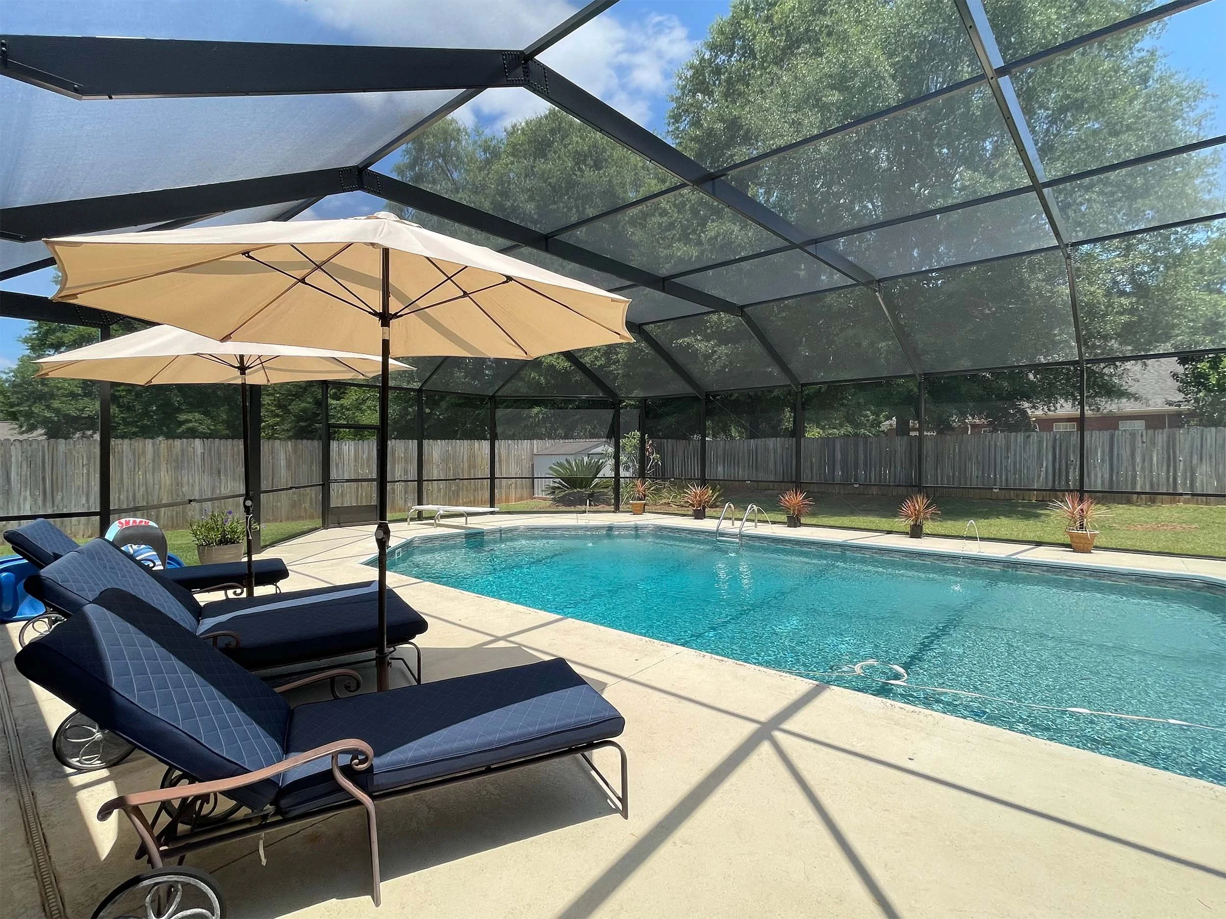 Pool cage installation creating a protected space for swimming and relaxing.