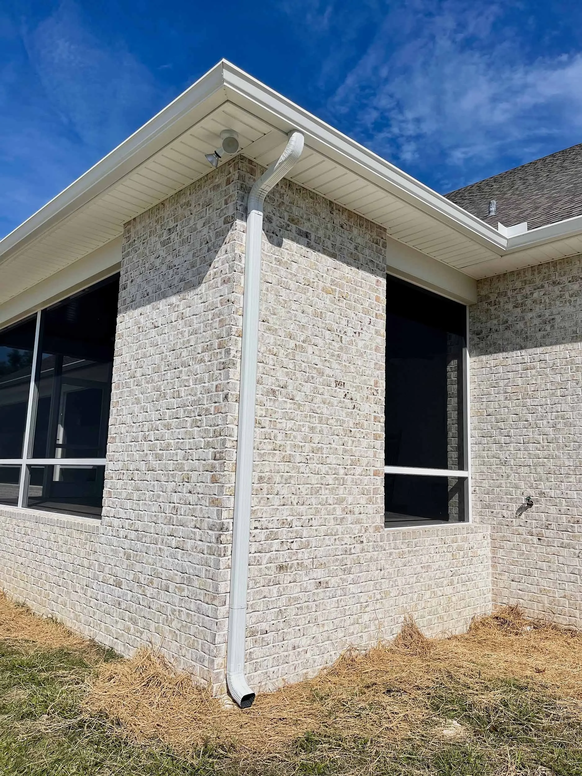 White seamless gutters installed along the roofline of a home.