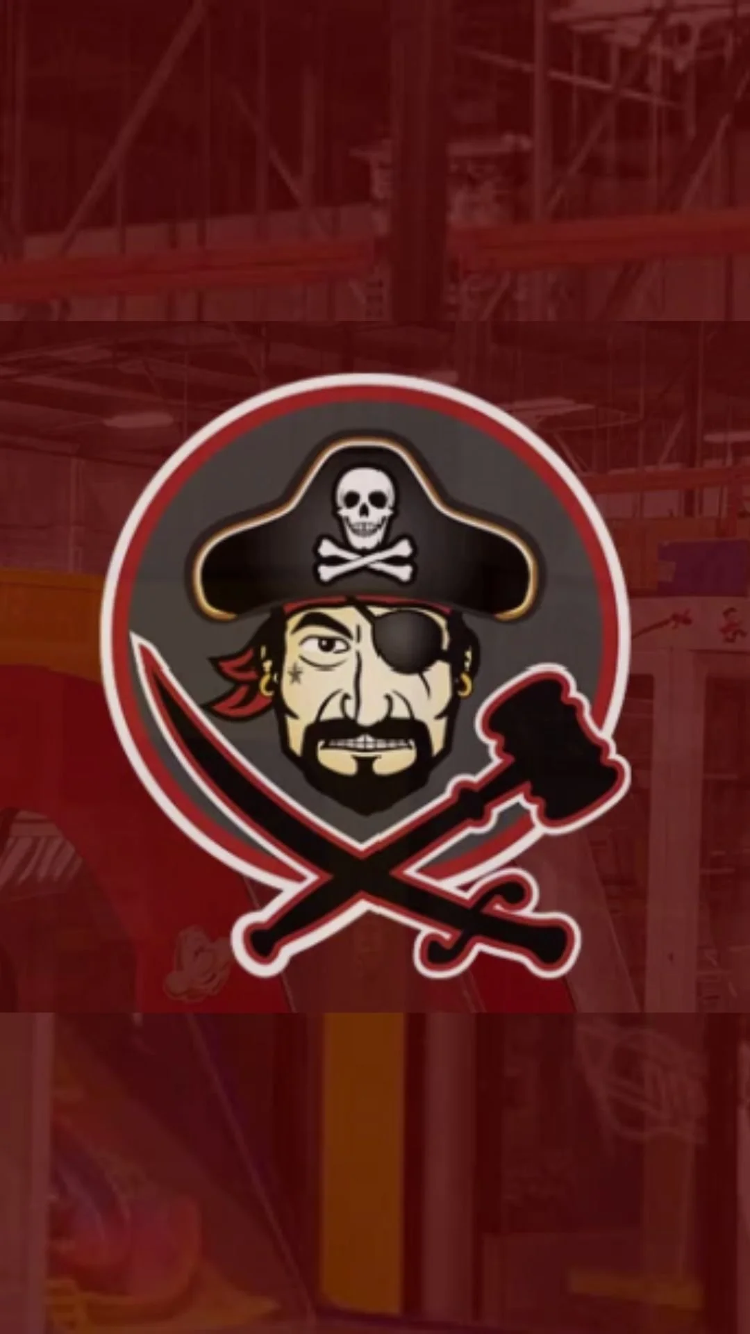 Pirate-themed team logo with a cartoon pirate face, wearing a black hat with a skull and crossbones, an eye patch, and a red bandana, with crossed swords underneath.