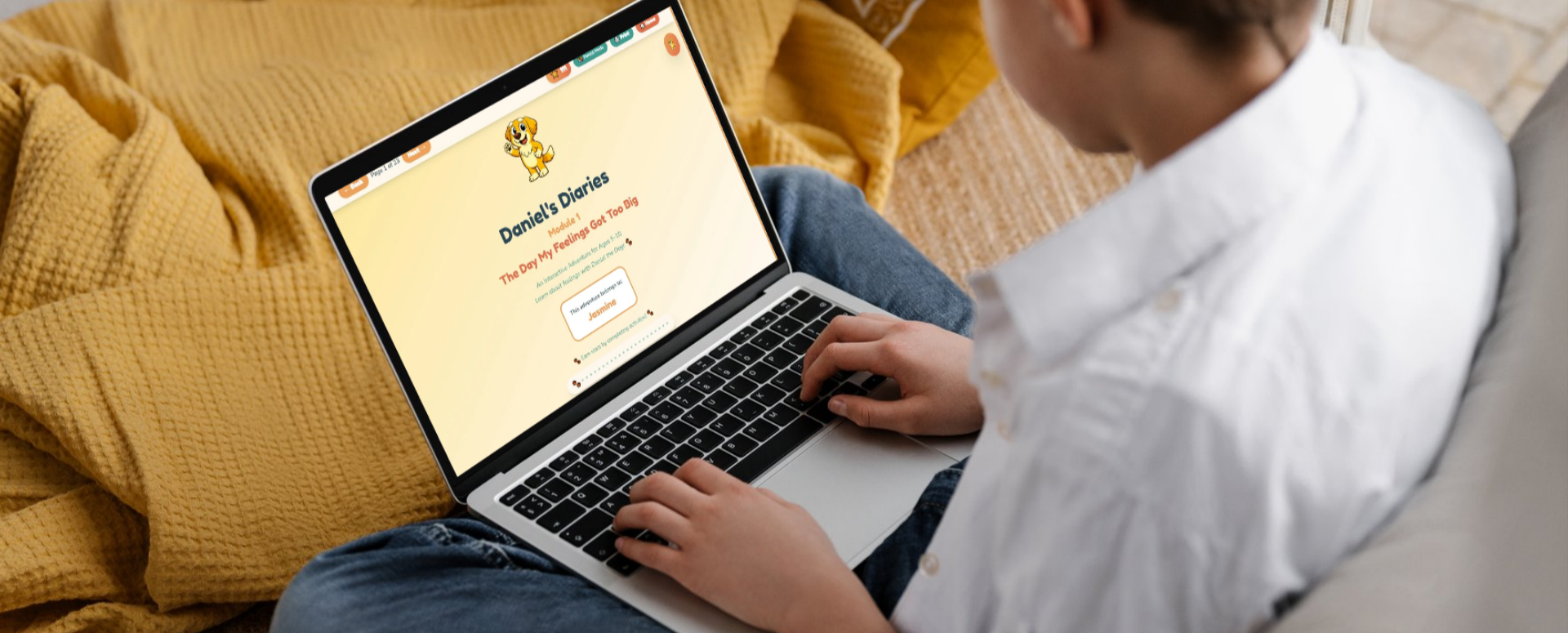 Person using a laptop on a yellow blanket, viewing a webpage titled "Daniel's Diaries" with a cartoon lion and colorful text.