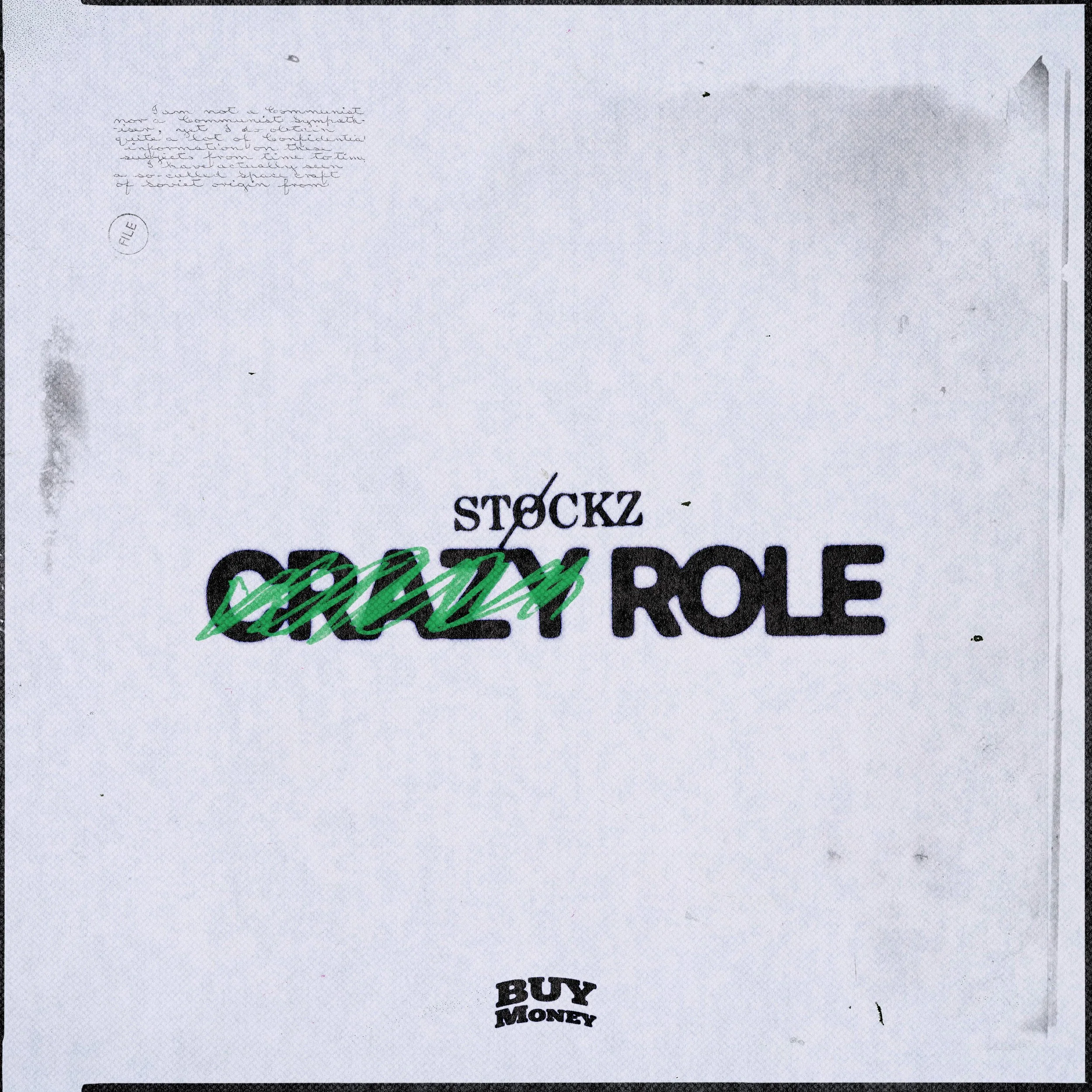 A white paper with the words 'stockz' and 'role' printed on it, with the word 'dream' written across in green. Additional small text and a 'BUY MONEY' logo are also visible.