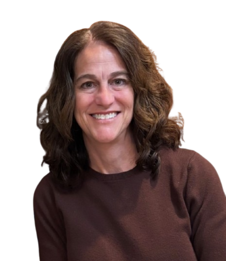 A woman with shoulder-length wavy brown hair smiling at the camera, wearing a brown sweater against a plain white background.