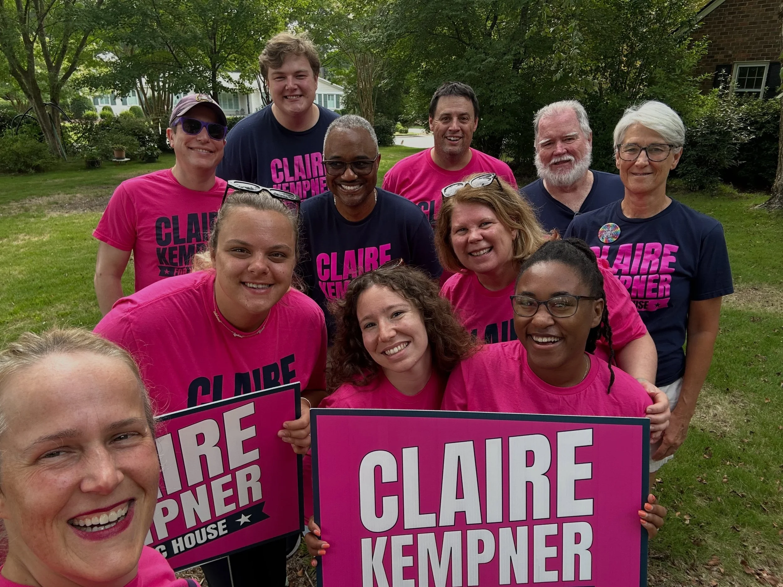 Group of Claire Kempner supporters with her pink yard signs.