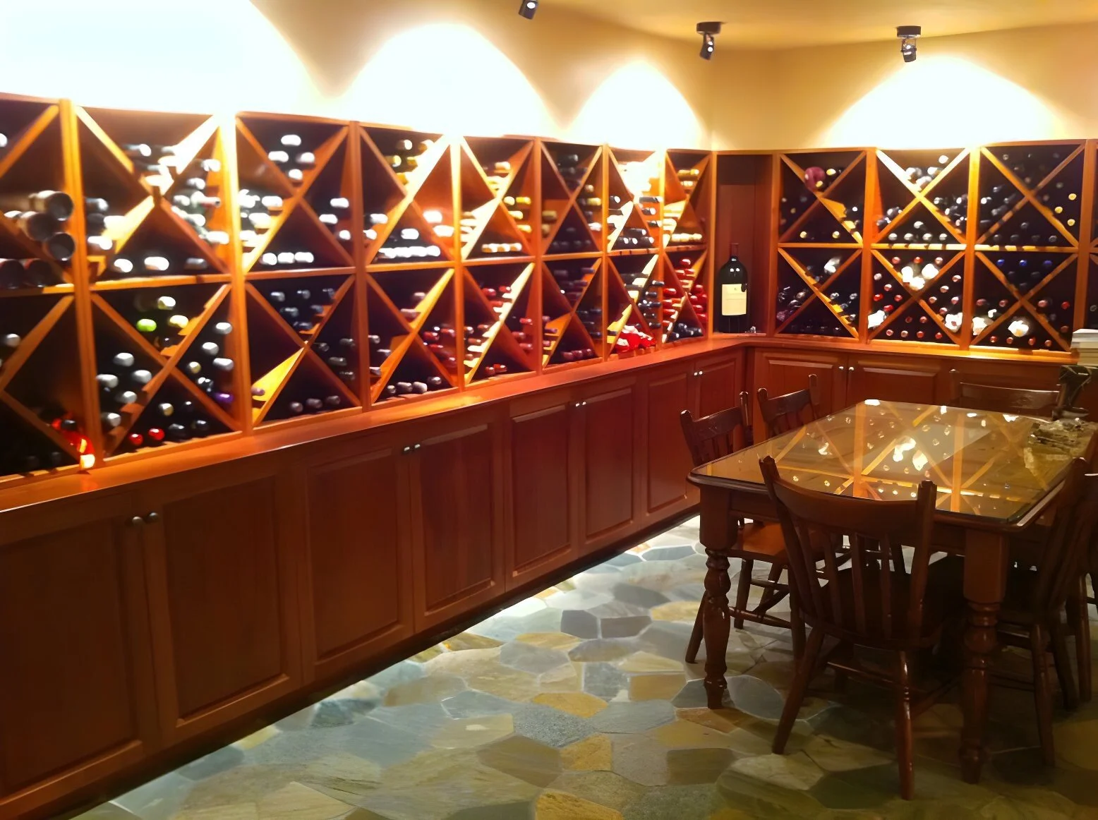Wine cellar with wooden shelves filled with wine bottles and a wooden table with chairs.