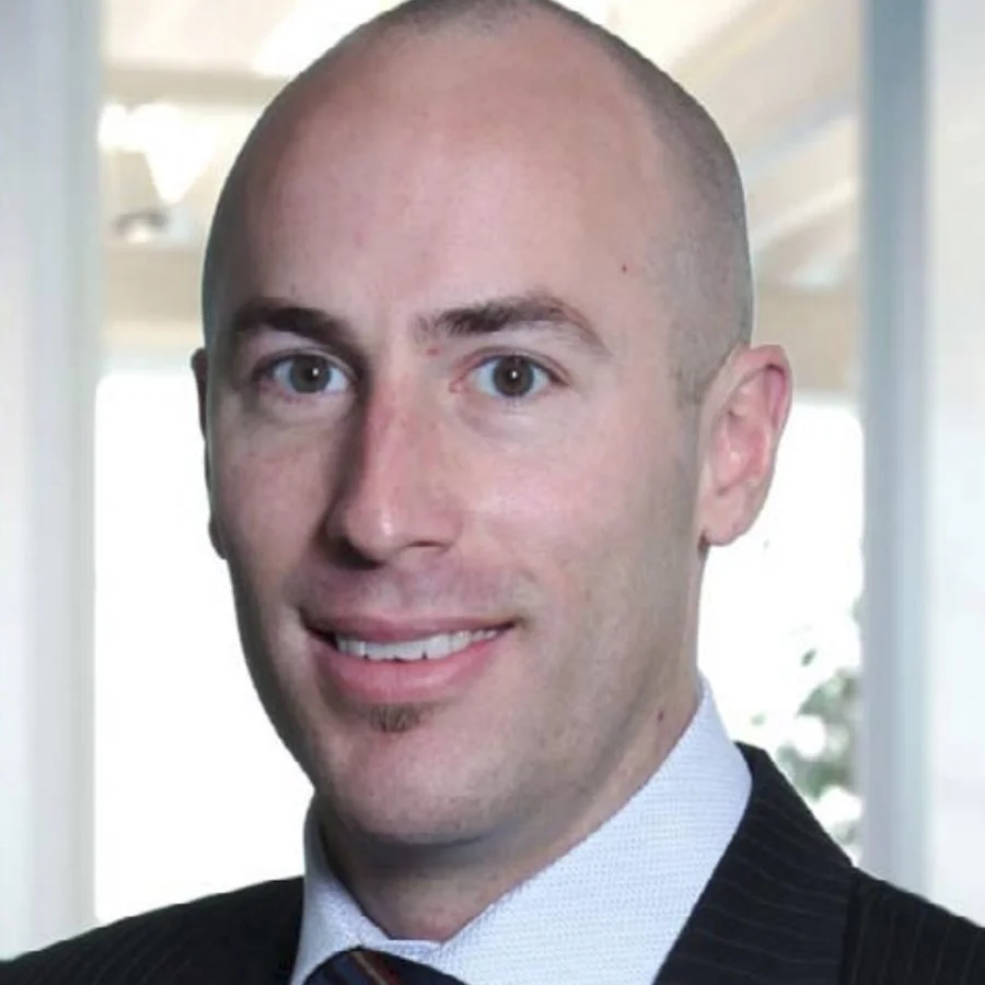 A smiling man with a shaved head wearing a suit and tie, indoors with large windows in the background. Clinton McNair

COO, Warwick Structures Group