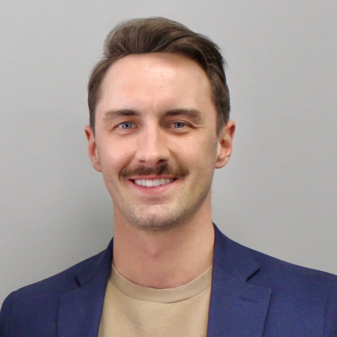 Headshot of a young man with brown hair, mustache, blue eyes, wearing a navy blazer and beige shirt, smiling, against a plain light gray background. Larson Laing

President, Laing Co Holdings Inc.