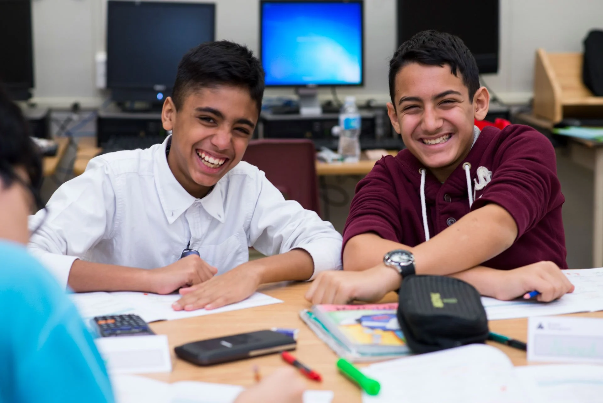 Students smiling at a table during a JA (Junior Achievement) Southern Alberta classroom program