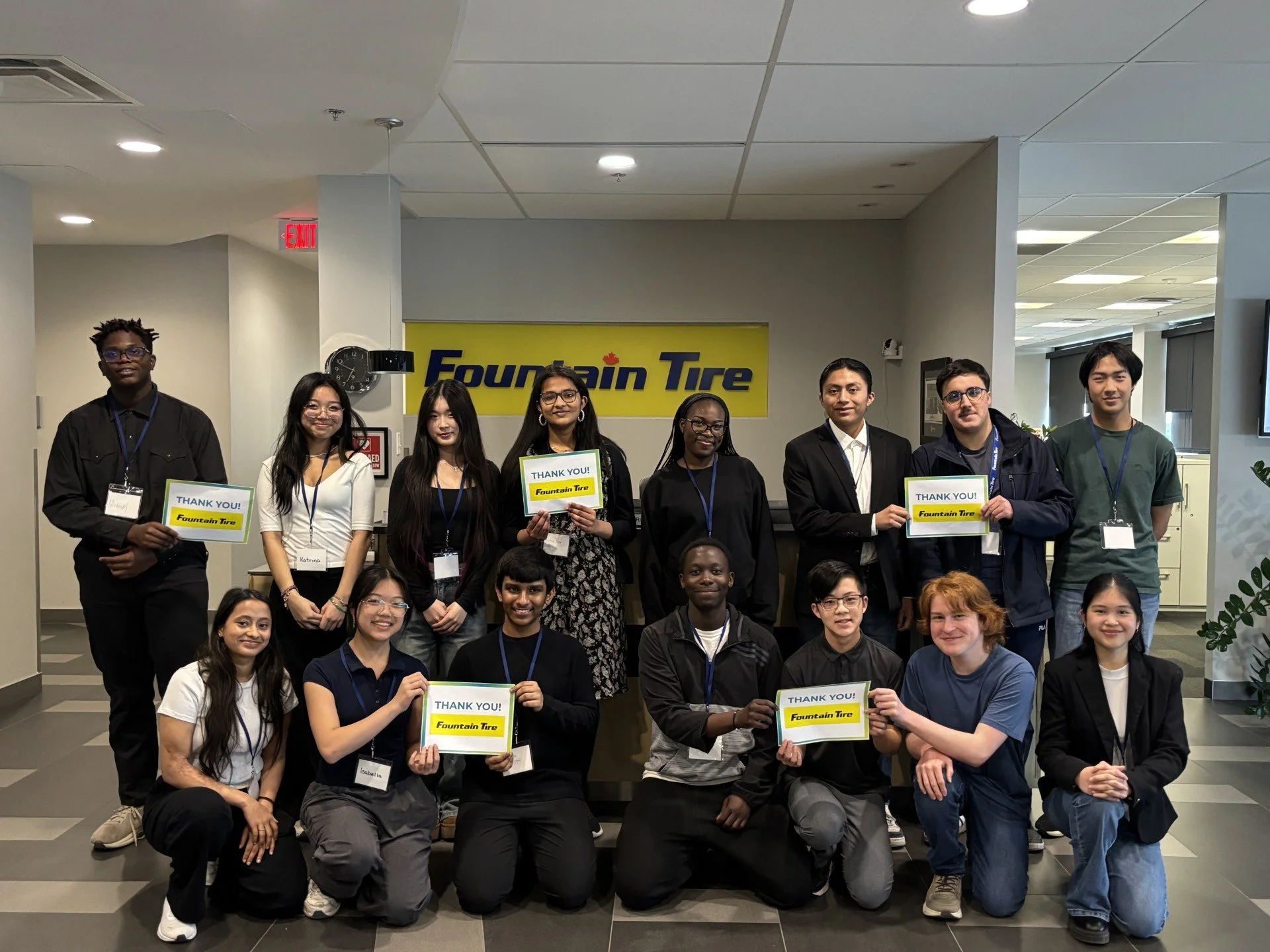 JA (Junior Achievement) Southern Alberta students holding thank you signs in front of a Fountain Tire sign