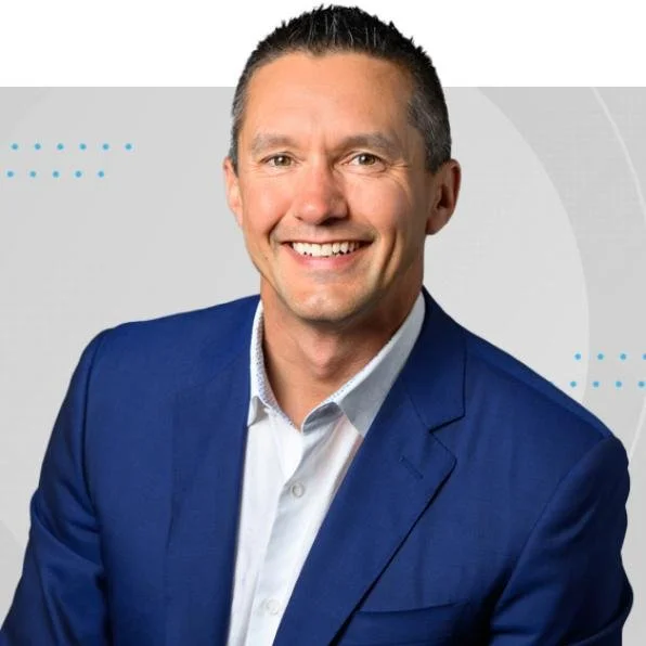 A smiling man in a blue suit jacket and white dress shirt, posing against a light gray background with blue dotted accents. Lee Raffey

CEO Eye Recommend