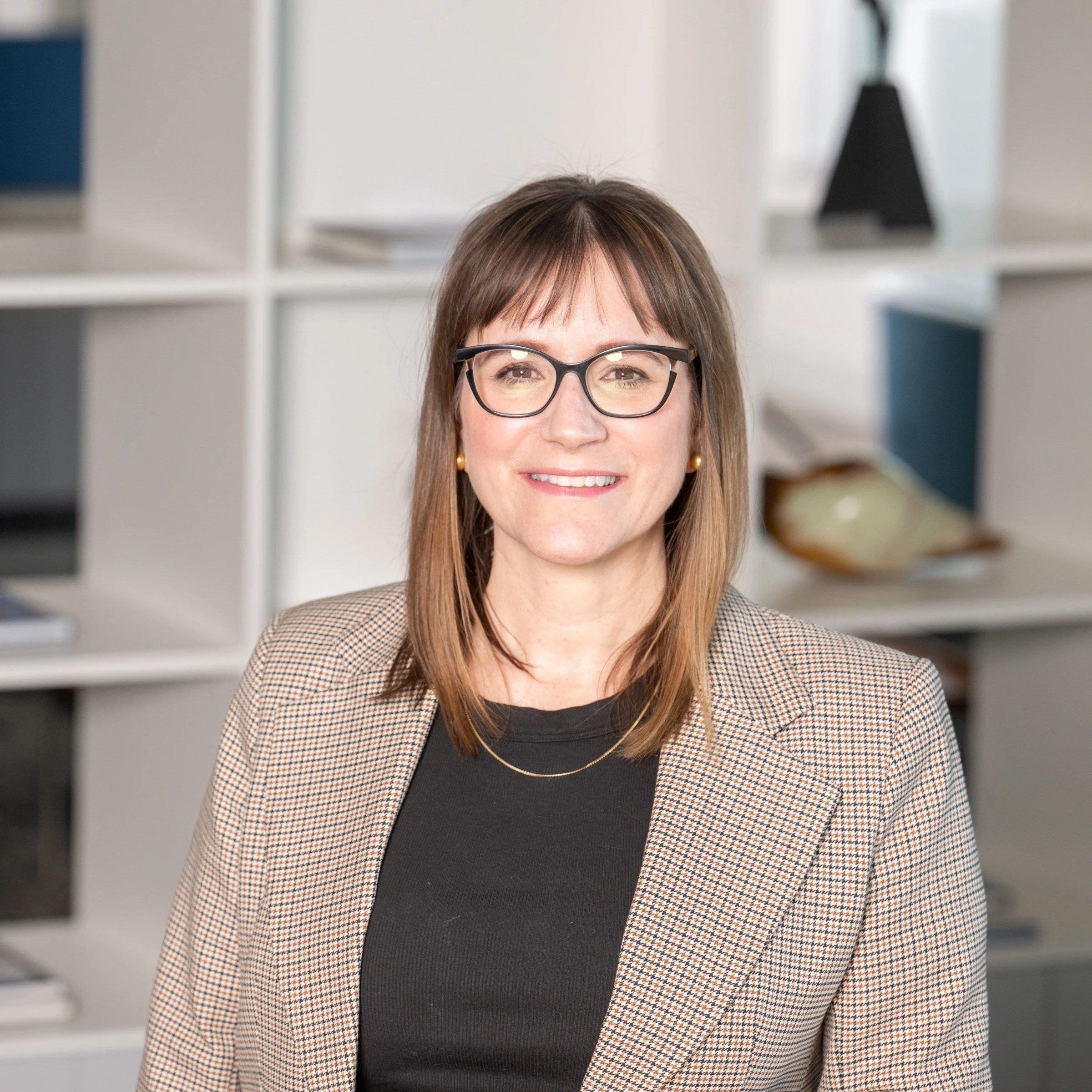 Close-up of a smiling woman with brown hair, wearing glasses, a black top, and a checked blazer, in an office setting with shelves in the background. Raylene Charron

CIO & VP, Information Services, TC Energy