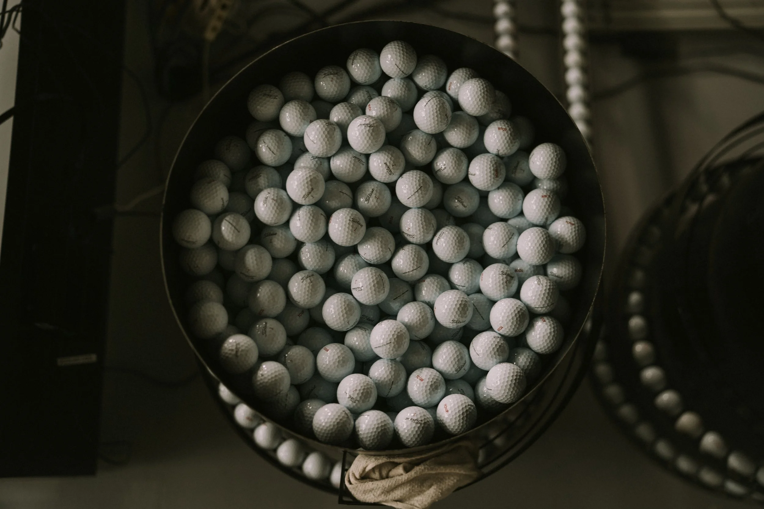A large circular container filled with many white golf balls.
