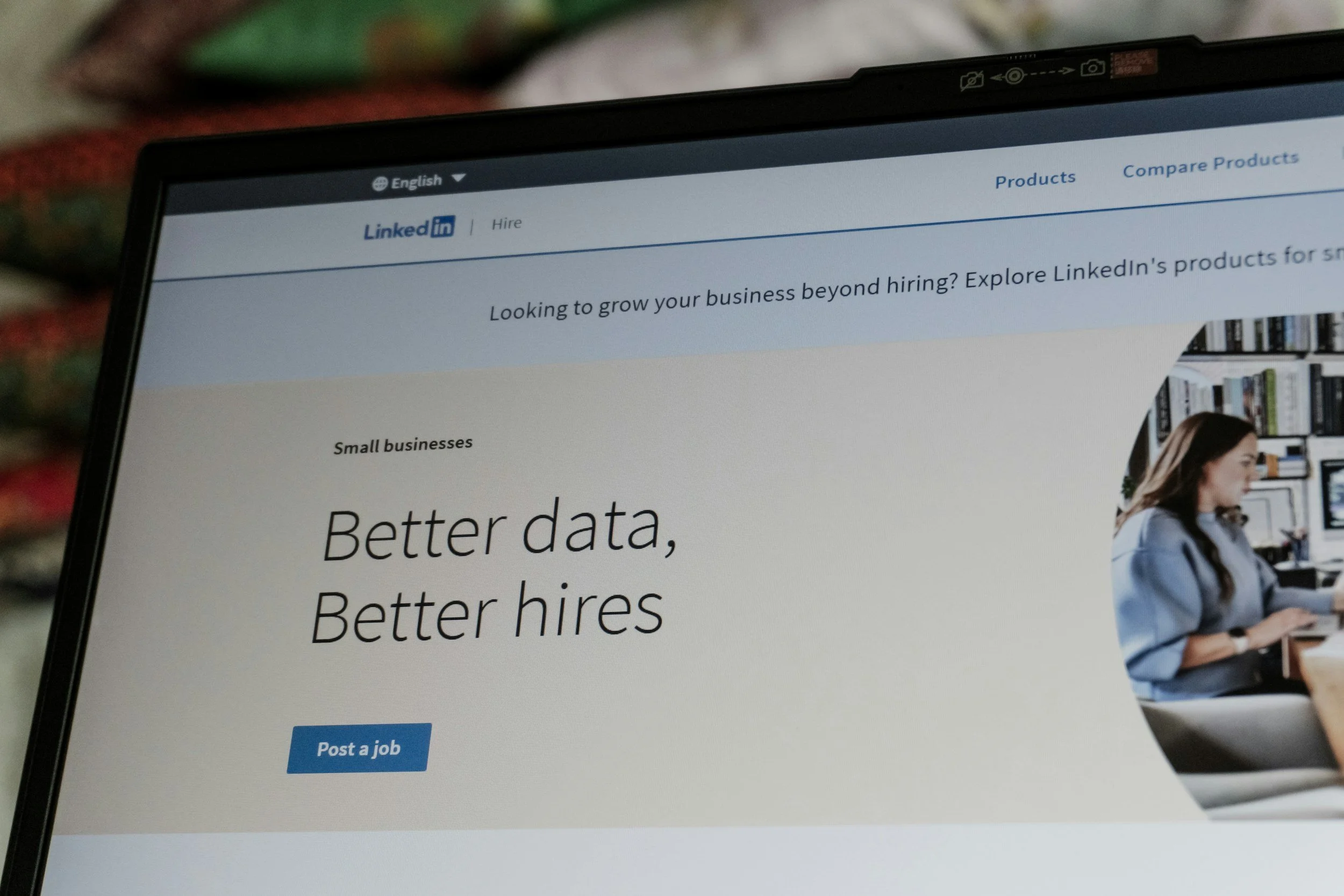 Laptop screen displaying the LinkedIn website with a banner about growing your business beyond hiring, featuring text 'Better data, Better hires' and a 'Post a job' button.
