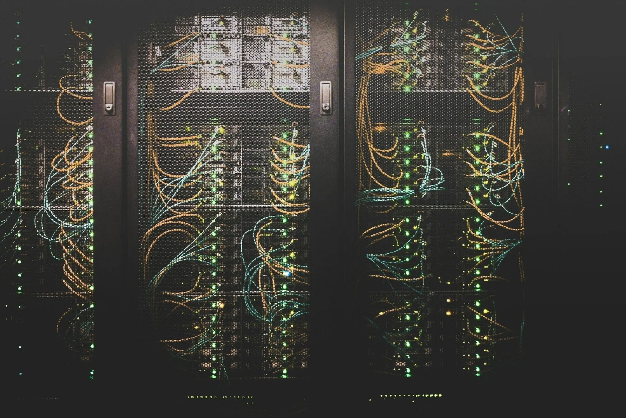 A server rack filled with interconnected network cables and blinking LED lights in a data center.