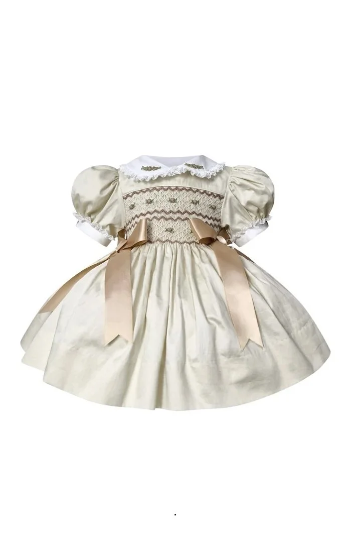 Vintage cream-colored dress with puffed sleeves, embroidered bodice, lace collar, and satin ribbon bows.