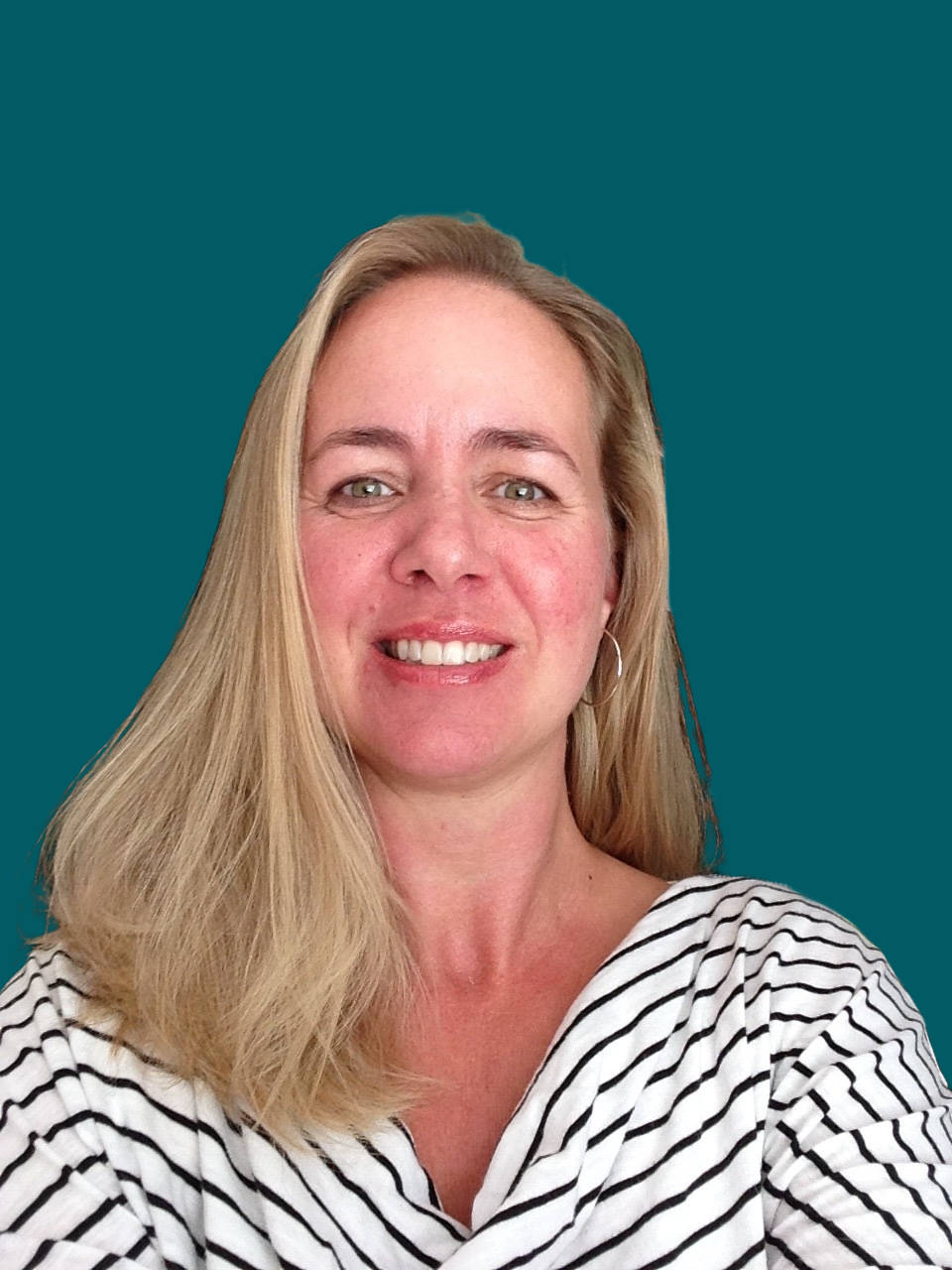 A woman with blonde hair smiling, wearing a black and white striped shirt, against a solid teal background.