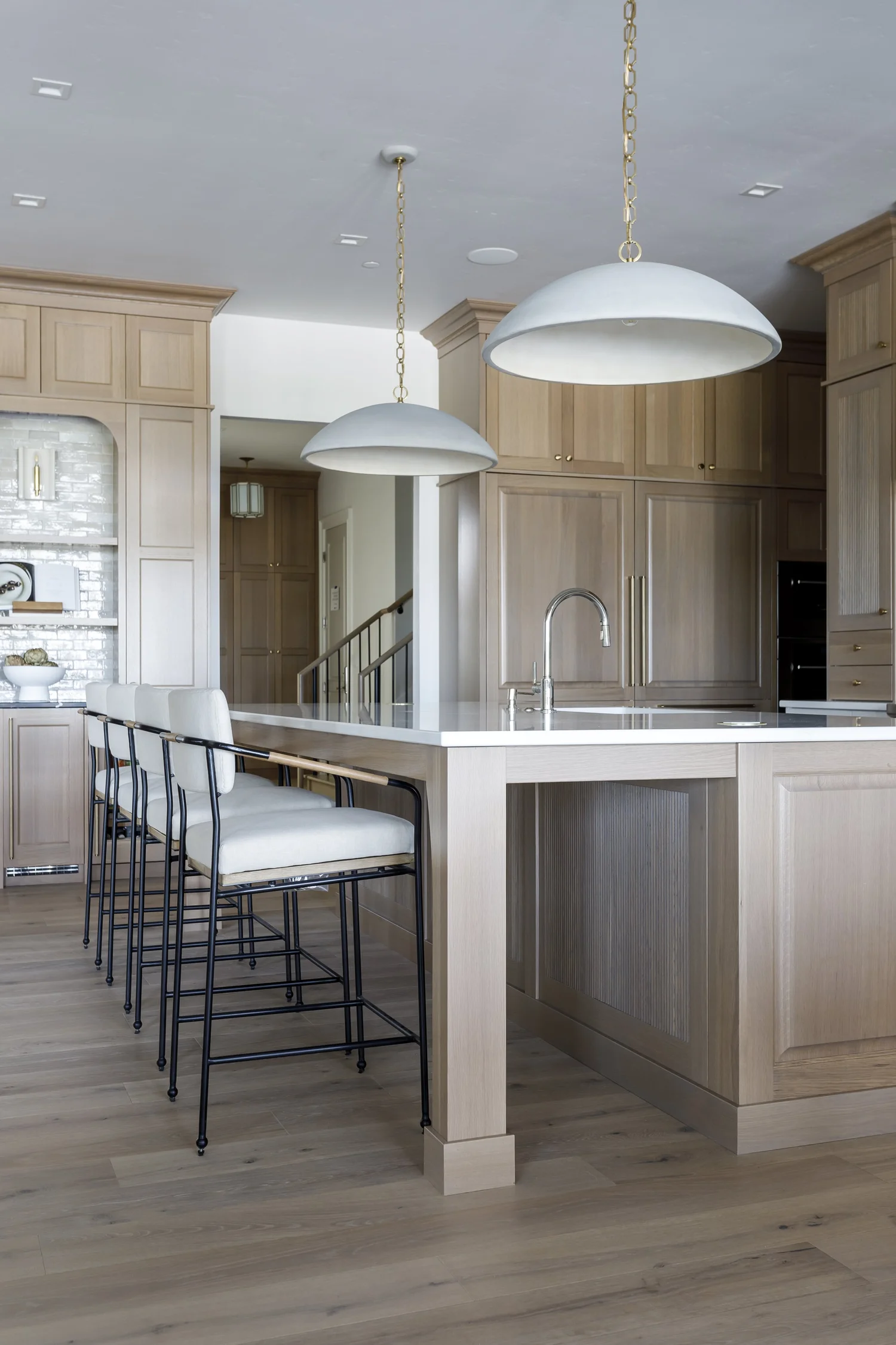 island, black stools, dome pendants