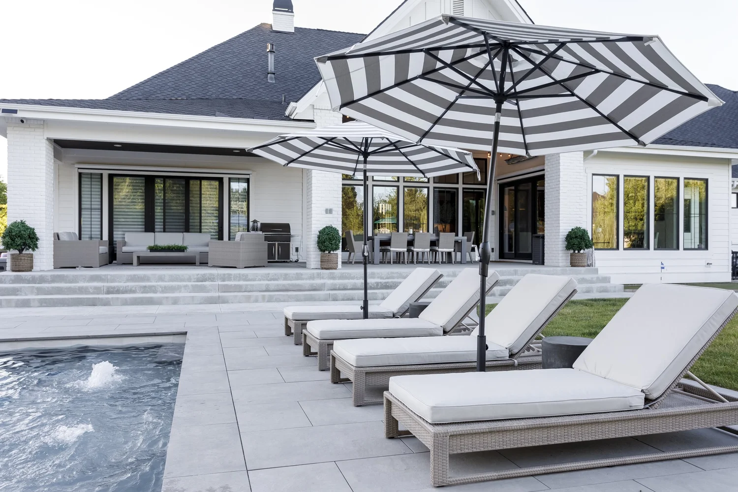 Outdoor patio with geometric umbrella, lounge chairs and pool