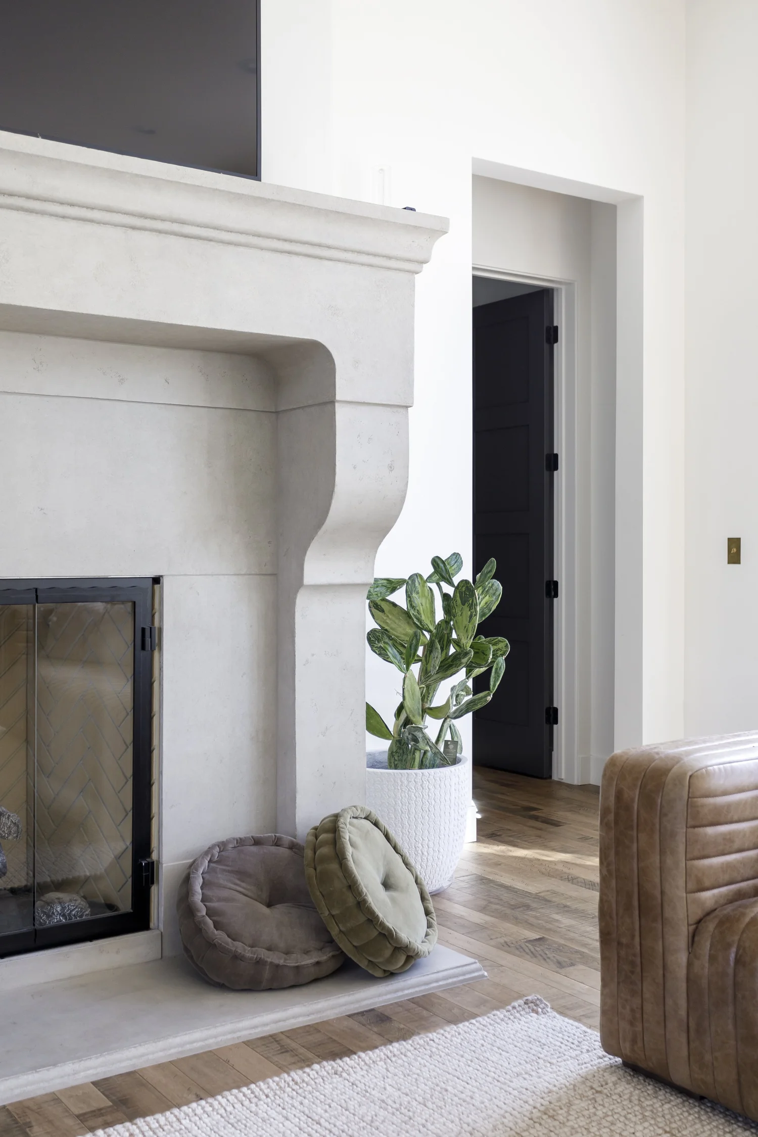 limestone fireplace, leather chair, plant