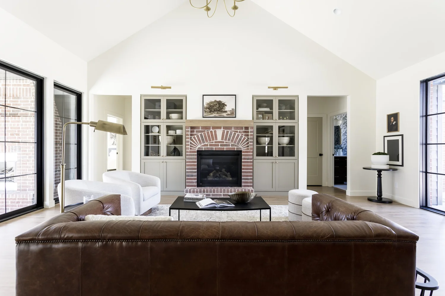 brown leather sofa, brick fireplace, vaulted ceiling