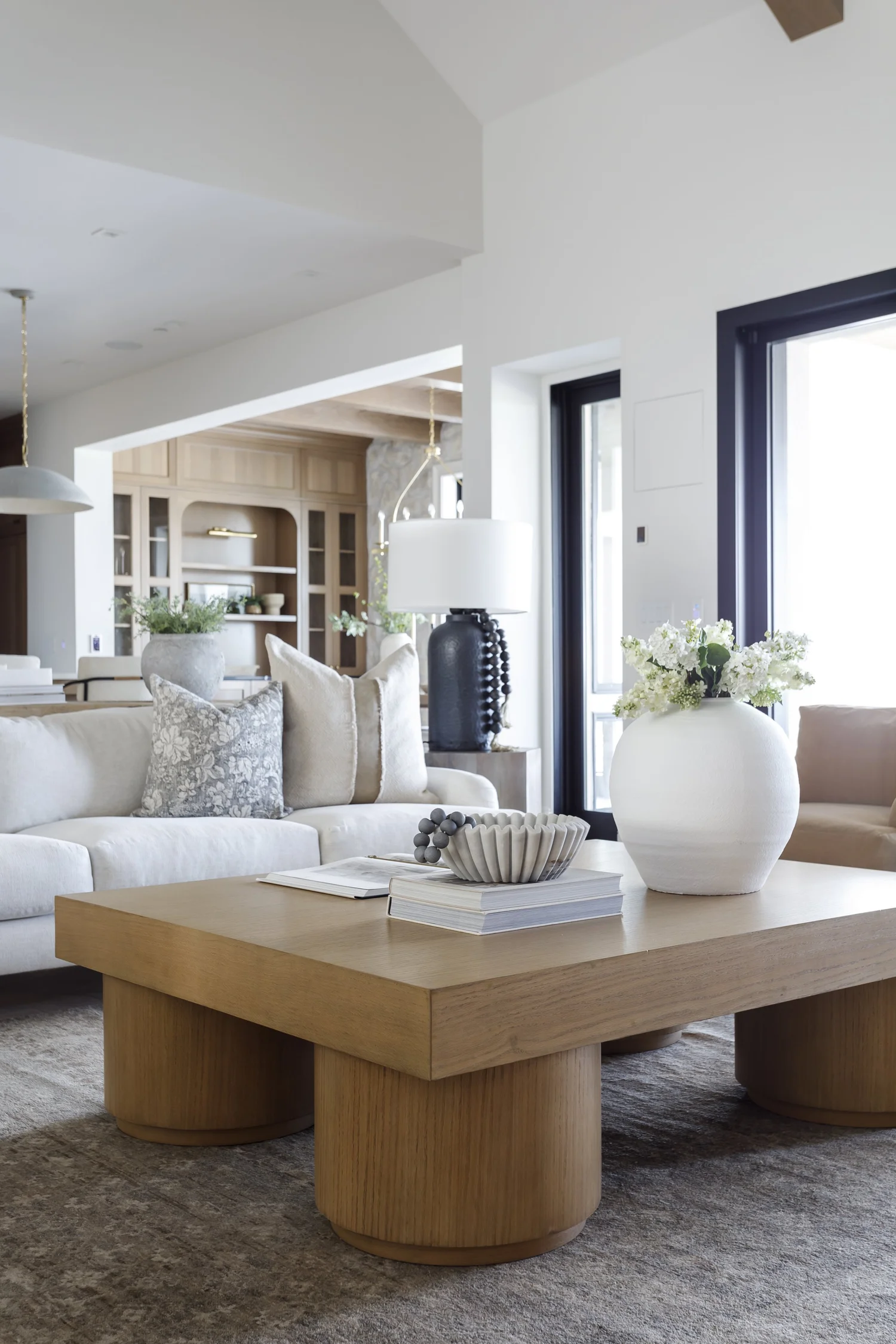 sofa, round wood coffee table, windows