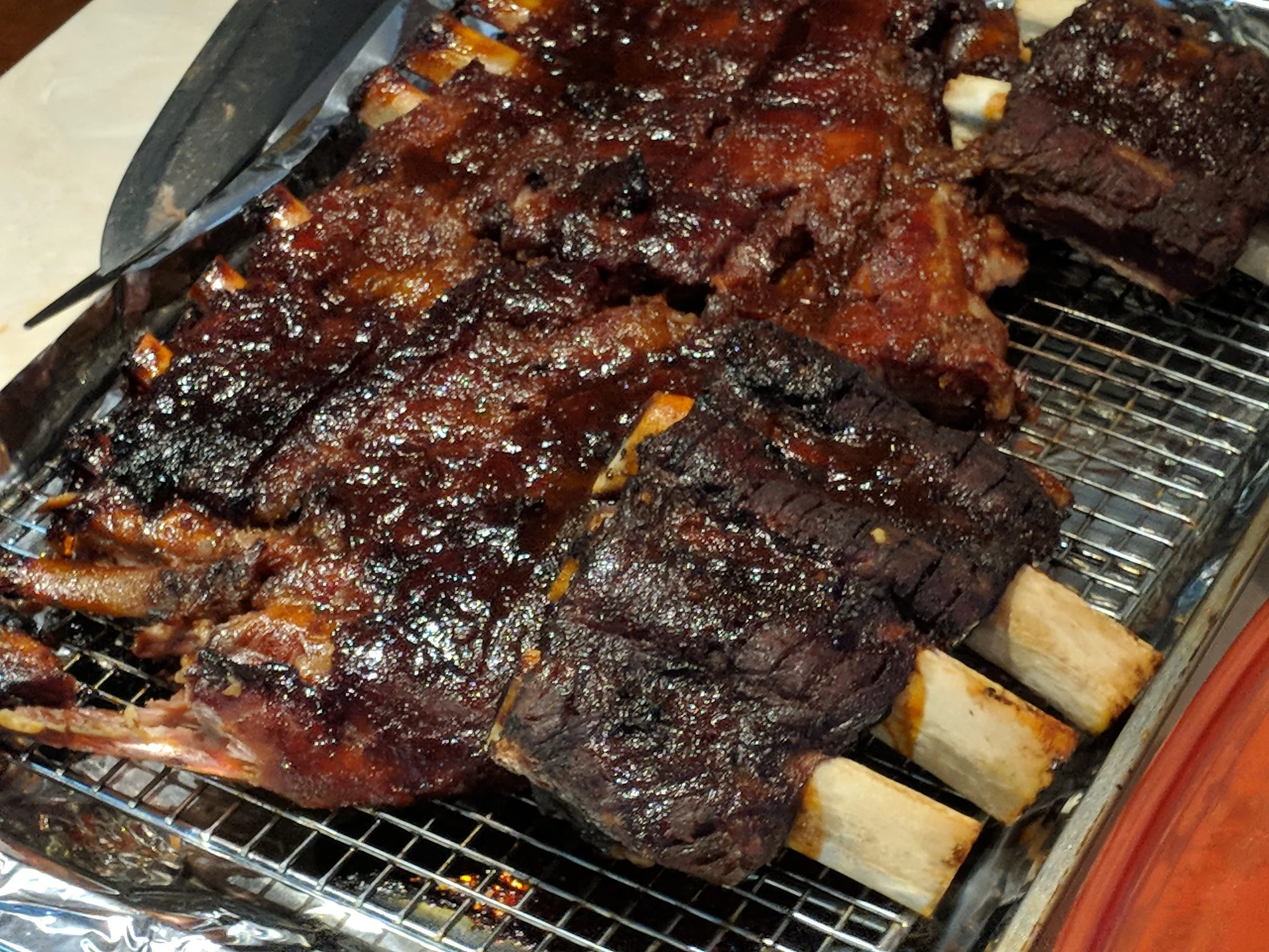 Barbecue ribs with sauce on a wire rack.