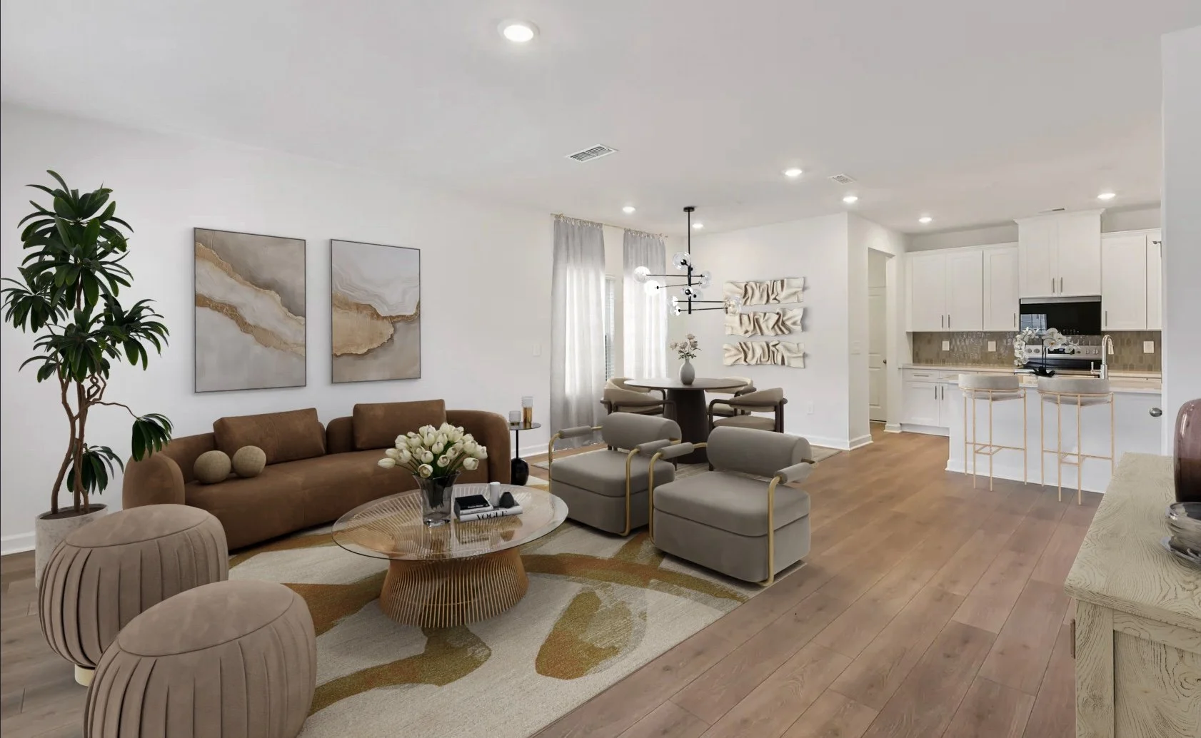 Open-concept living room and kitchen with beige, taupe, and white decor, wooden flooring, sofa, armchairs, round marble coffee table, potted plant, wall art, dining table, bar stools, and kitchen appliances.