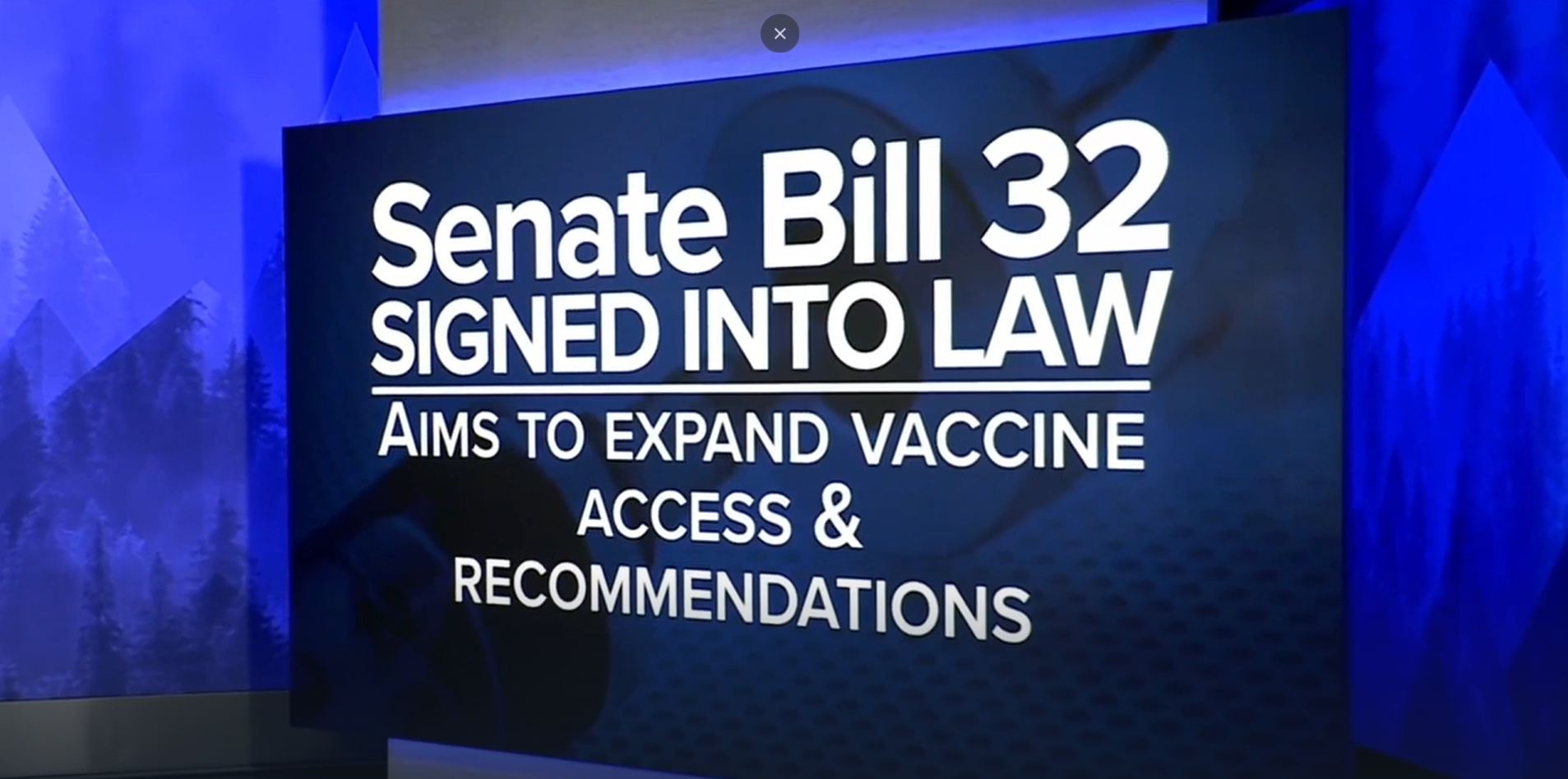 News headline sign that reads "Senate Bill 32 Signed into Law: Aims to Expand Vaccine Access & Recommendations"