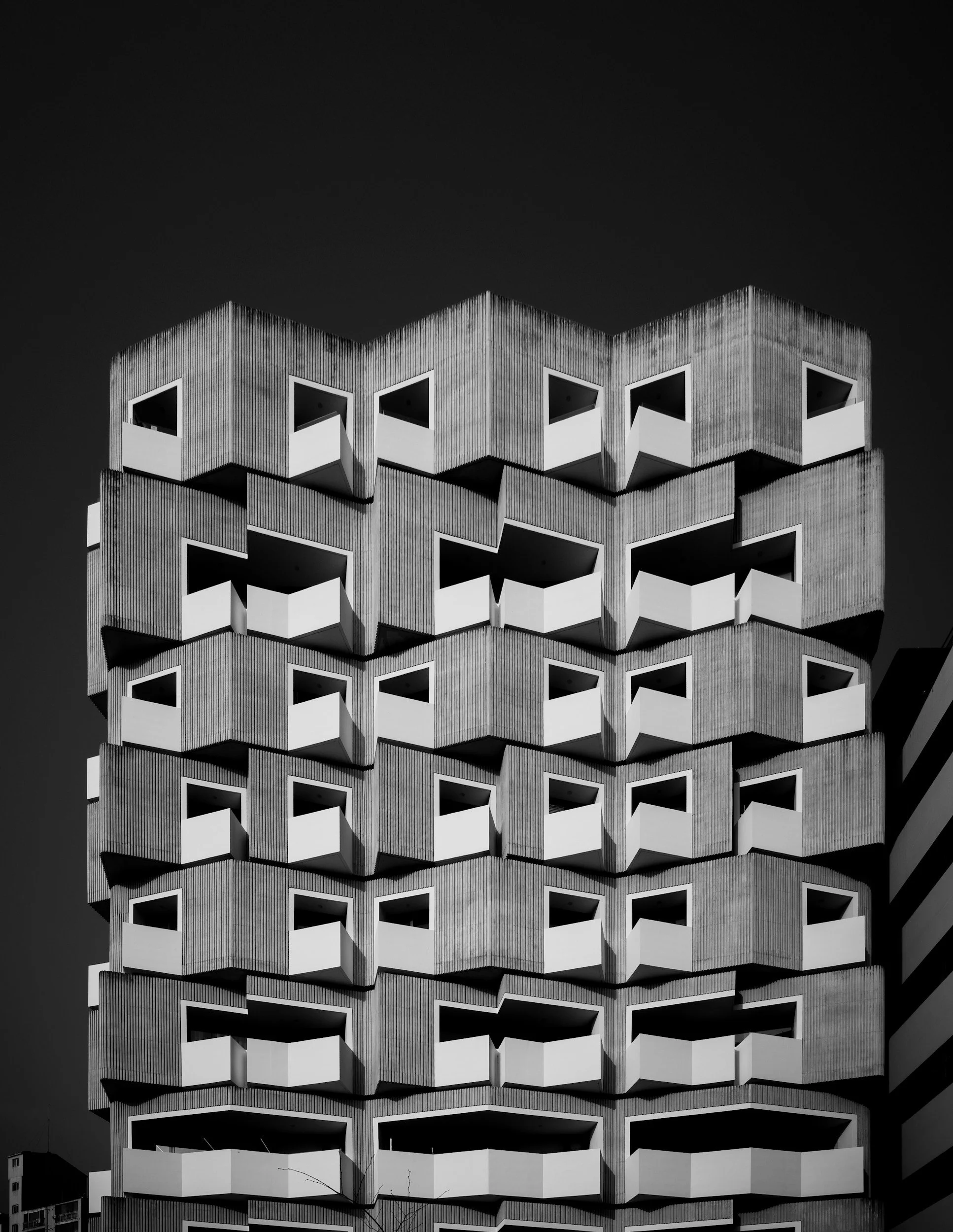Monochrome photo of a modern building with repeating cube-shaped balconies.