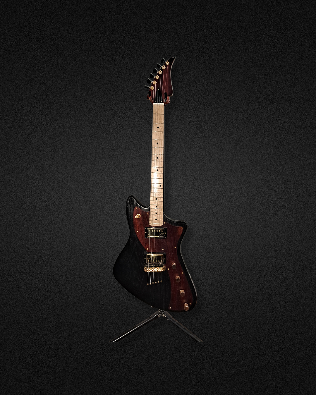 An electric guitar with a black and dark red finish on a black background.