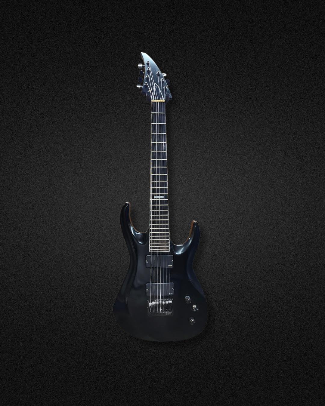 A black electric guitar with a sleek, modern design, set against a black background.