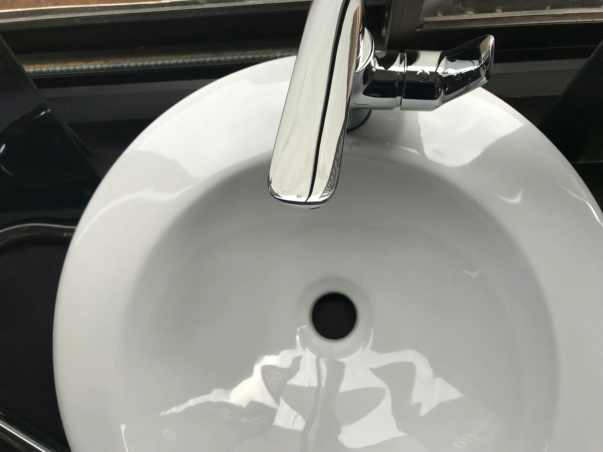 A white ceramic sink with a chrome faucet.