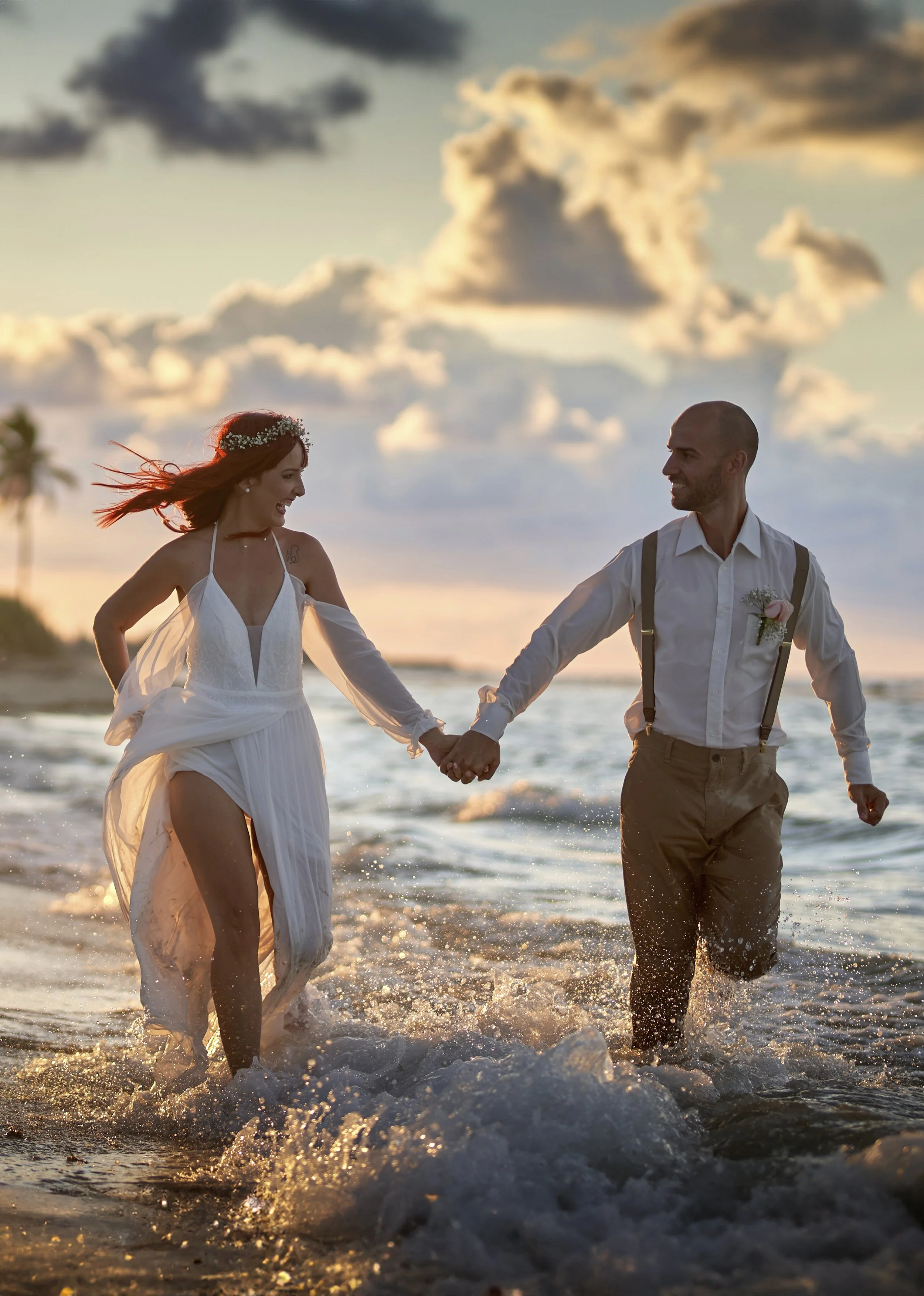 Mariana y Carmen, clientas de Laurie, tomándose las manos sobre un césped verde el día de su boda.
